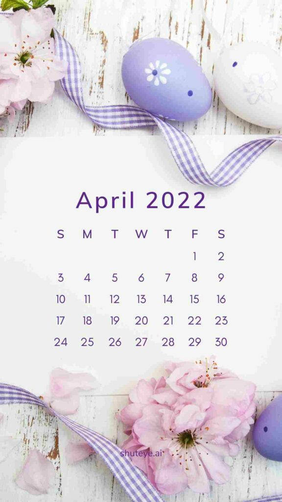 2022年4月日曆，在風化木上擺放紫色蛋和粉紅花朵。