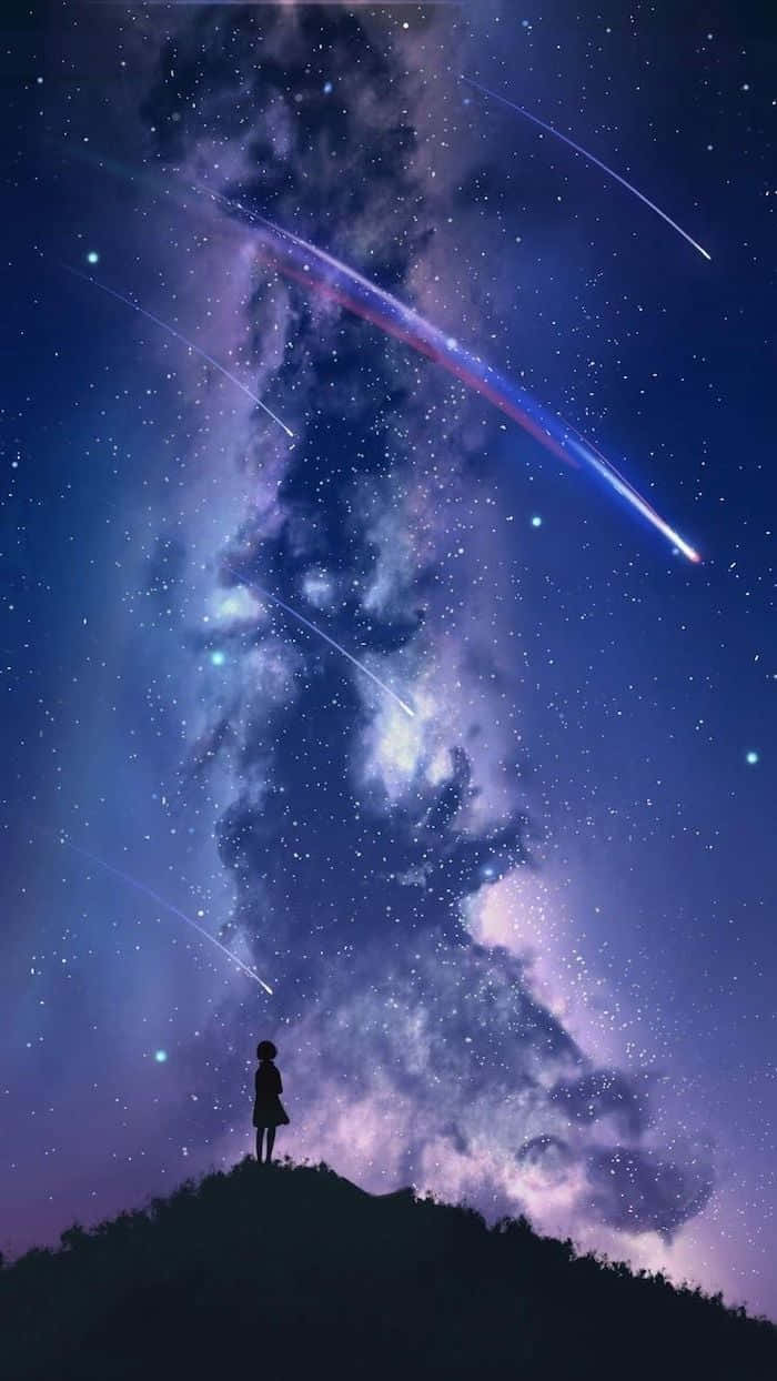 一個人在山丘上的剪影，觀看帶有流星的星空夜空。