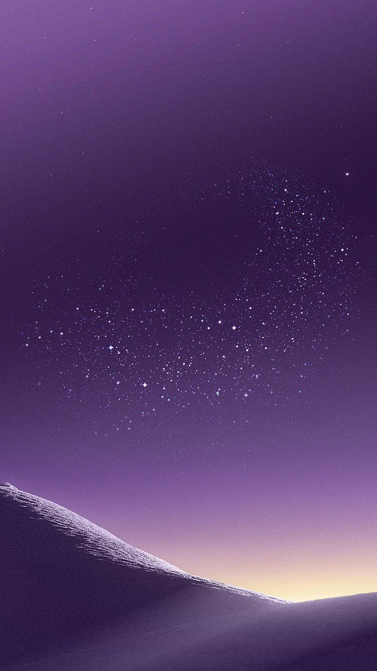 在繁星點點的紫色暮色天空下的積雪山脊