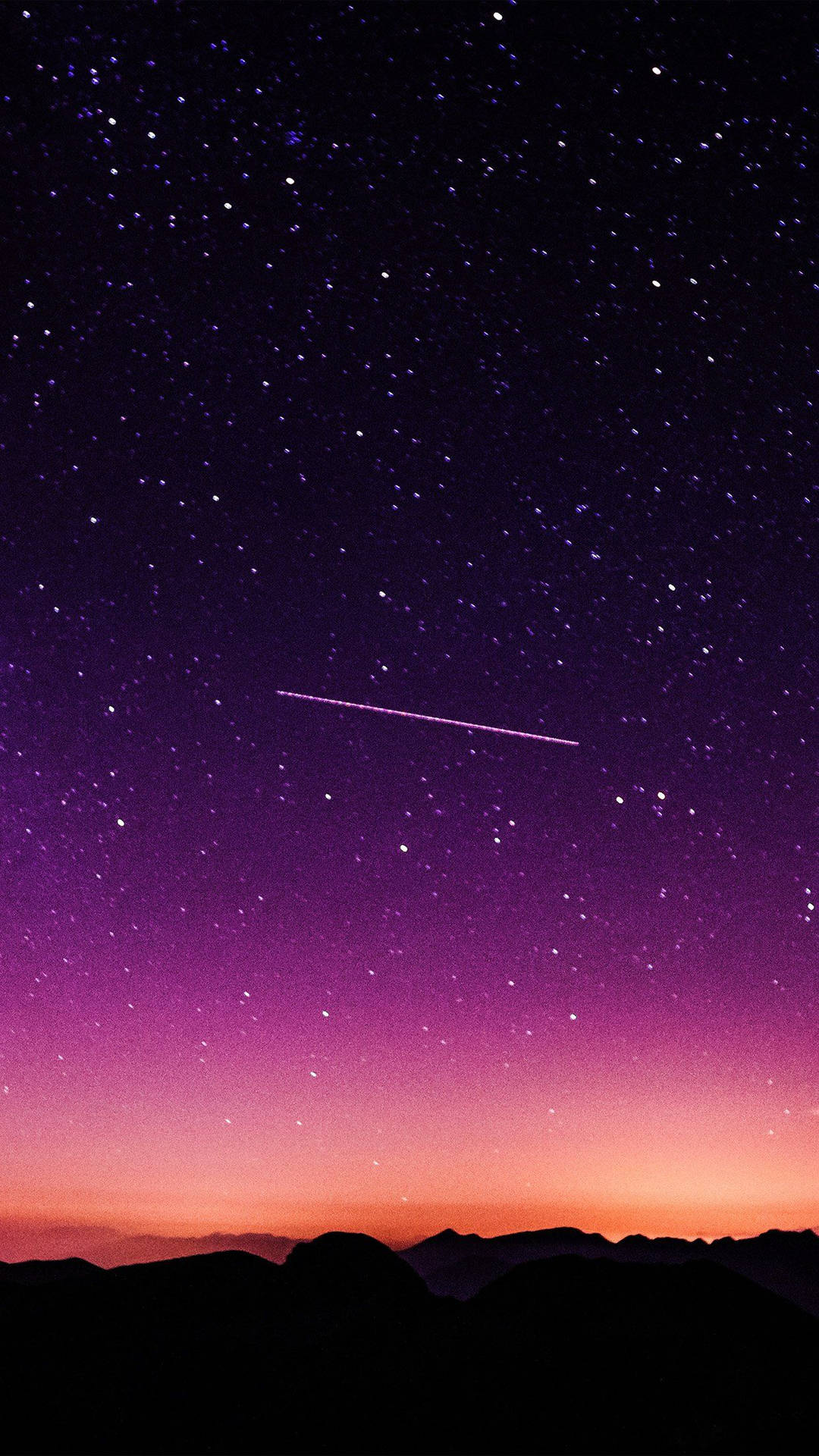 一顆流星劃過黑暗山脈輪廓上方的星空暮色天空。