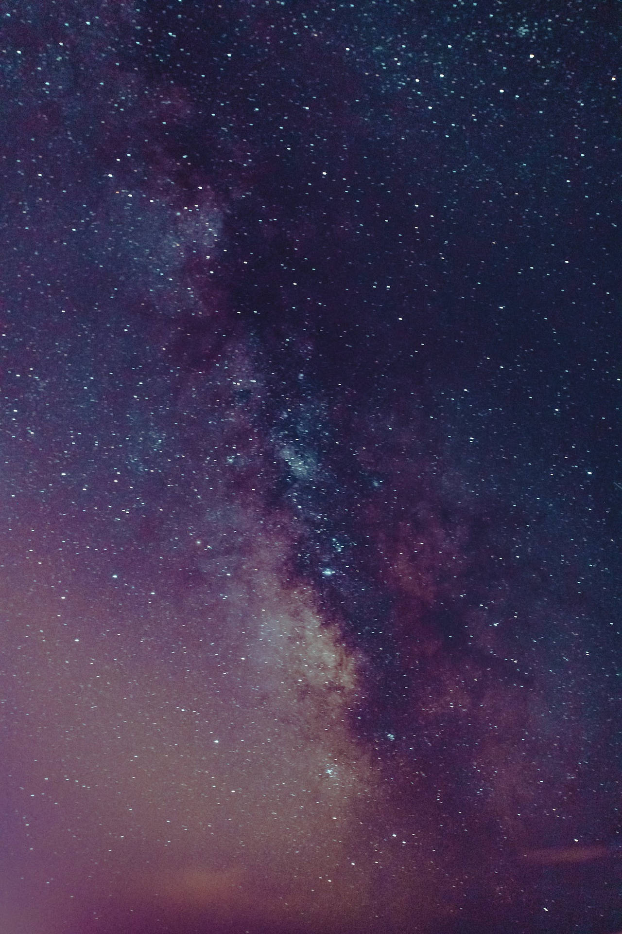 銀河系在黑暗的夜空中散發著紫色和藍色的星光。
