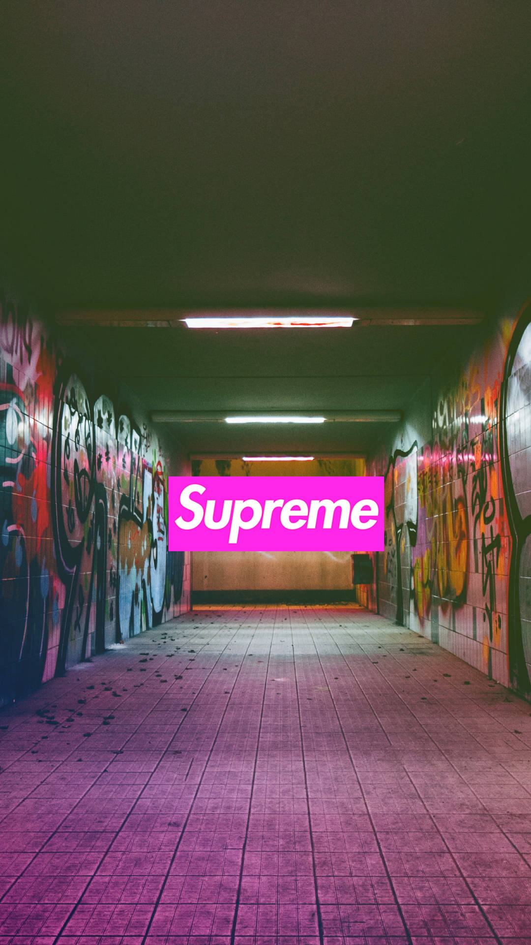 在一個佈滿塗鴉的城市隧道中，帶有紫色瓷磚地面的粉紅色Supreme標誌。