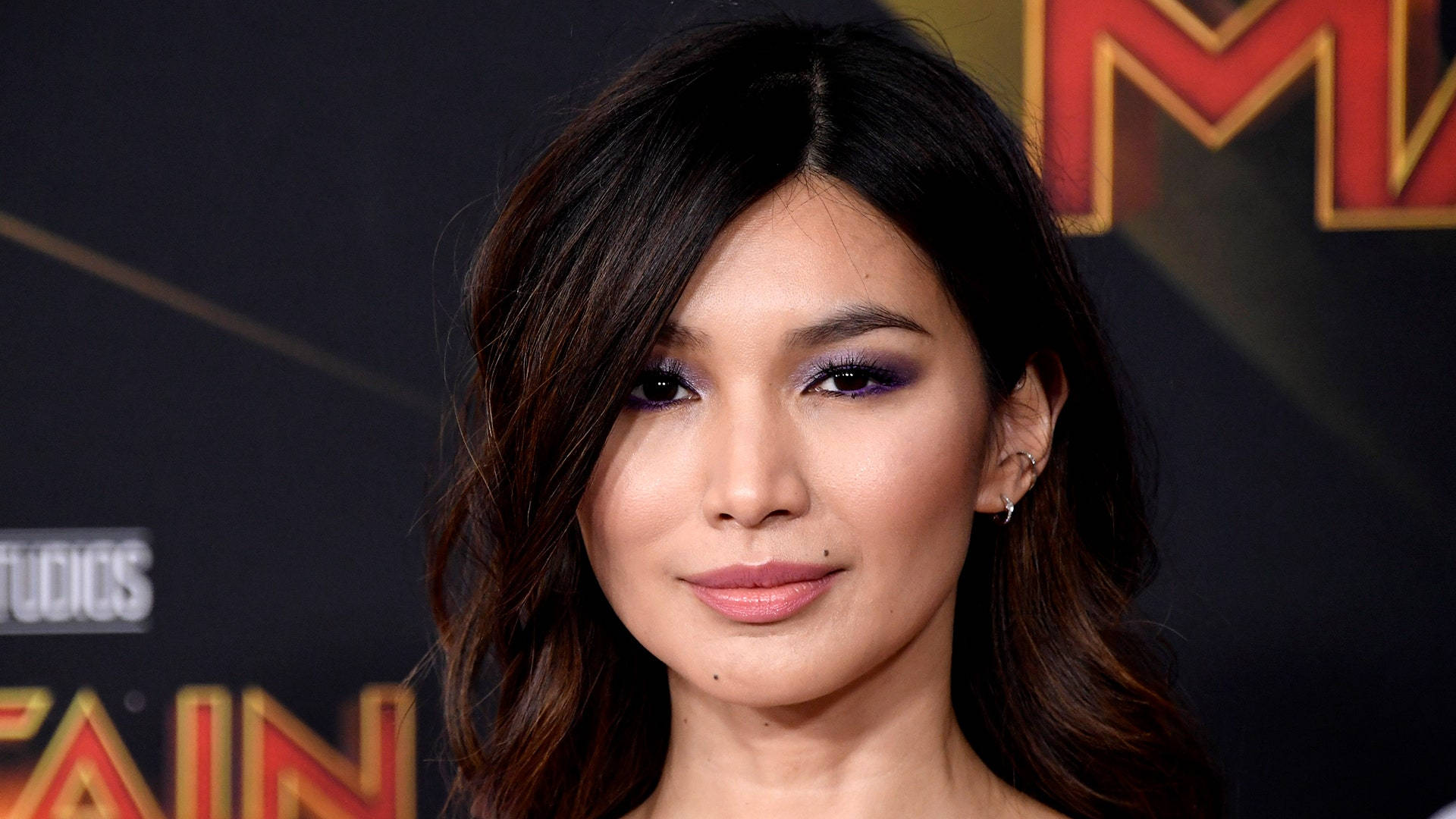 紫色眼影 Gemma Chan 壁紙 — 在Marvel Studios活動中，一位深色頭髮和紫色眼影女性的特寫肖像。