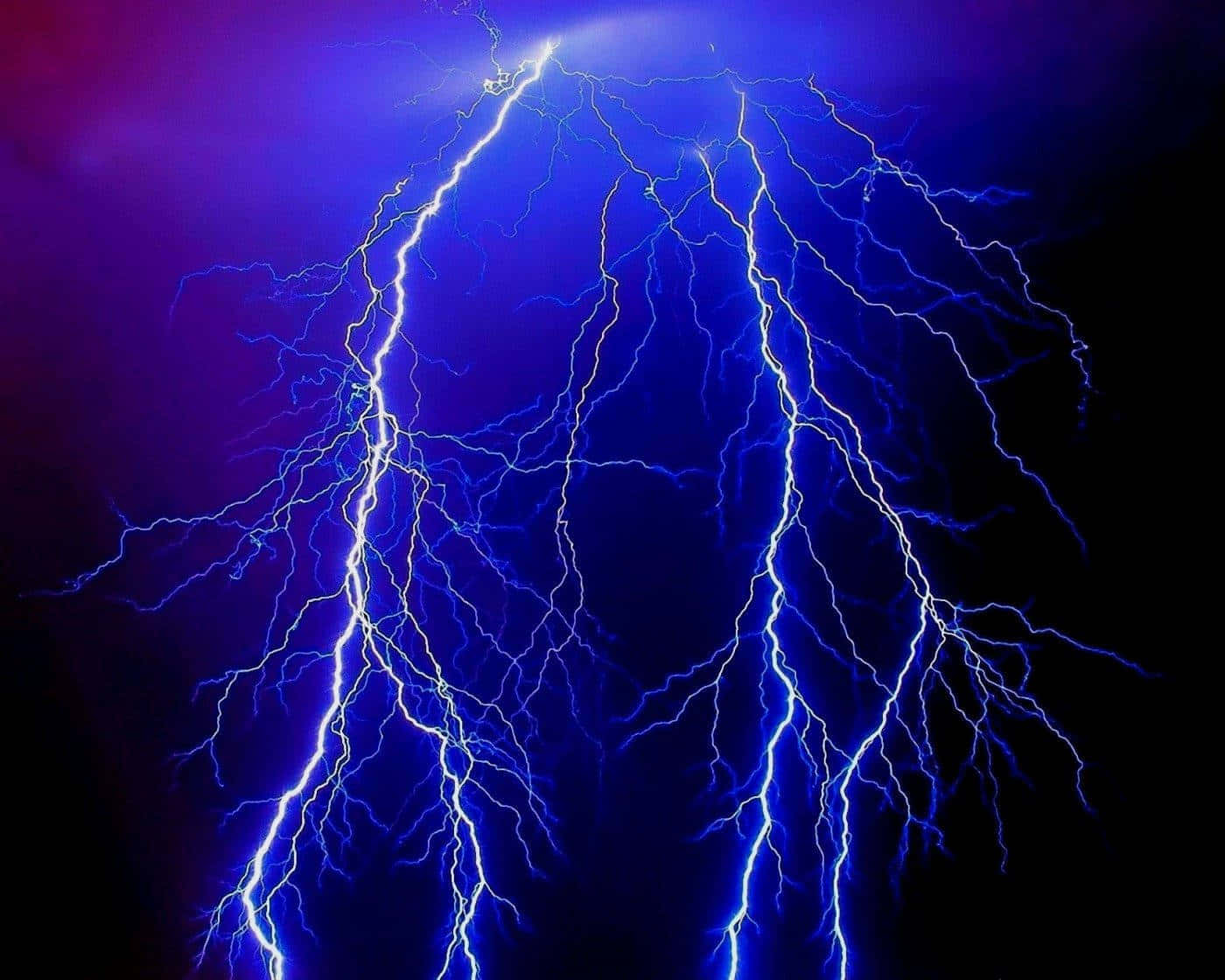 強烈的藍色閃電照亮了帶有紫色色調的黑暗暴風雨天空。
