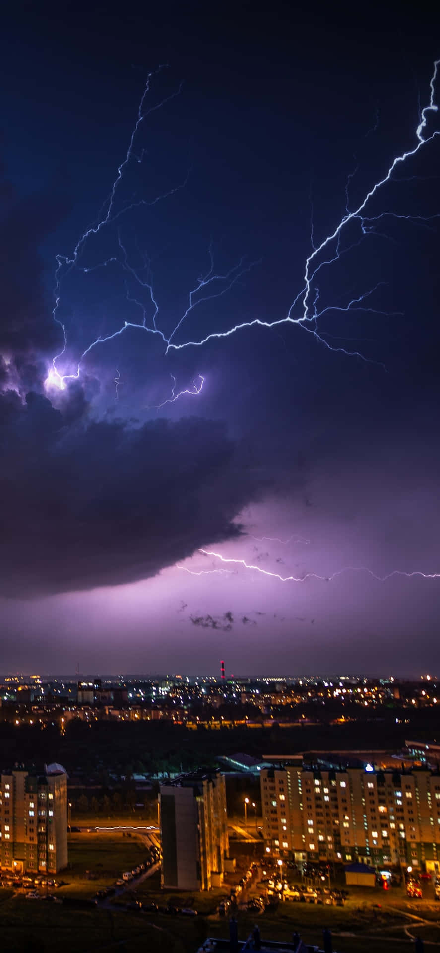 夜晚城市上空的閃電，下方是發光的建築物。