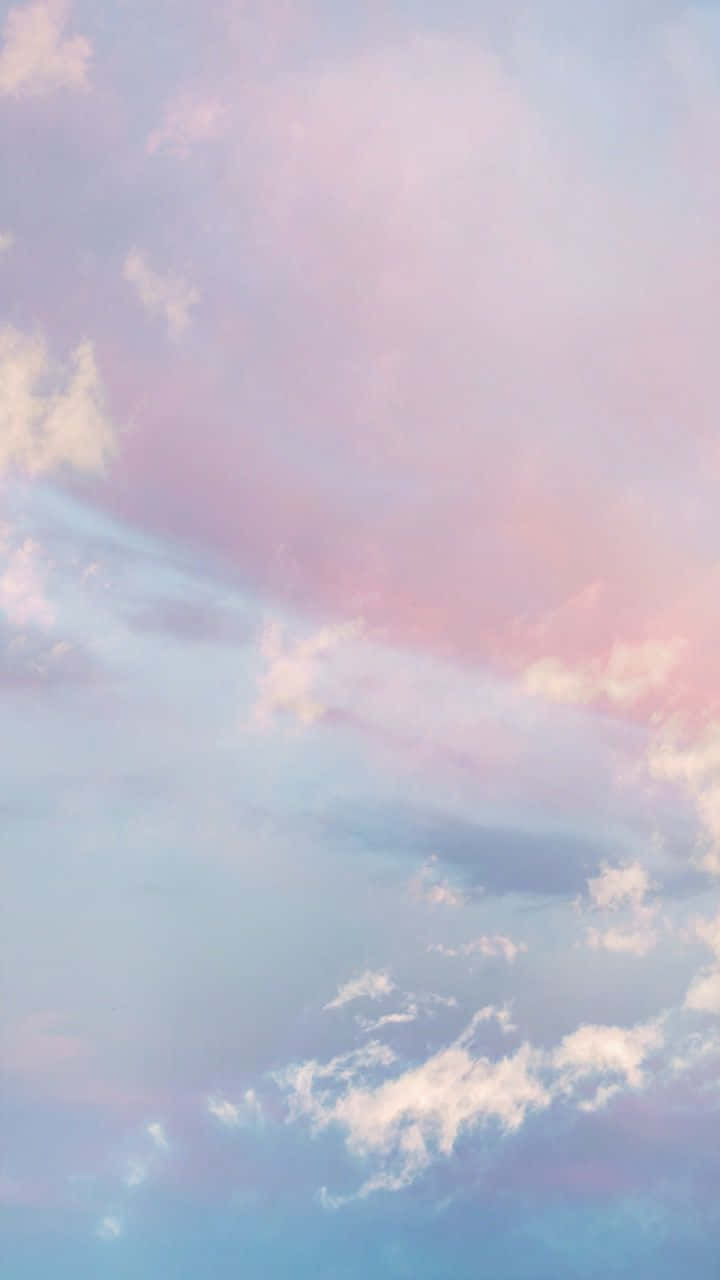 紫色雲朵與對比藍天的壯麗景觀 壁紙 — 柔和的粉彩雲在暮色中飄過寧靜的天空，天空塗上溫柔的粉紅、藍色和紫色。