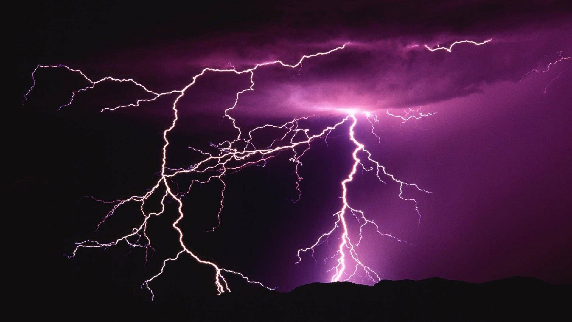 紫色閃電在暴風雨的夜空中，在黑暗的山脈上方劈啪作響。