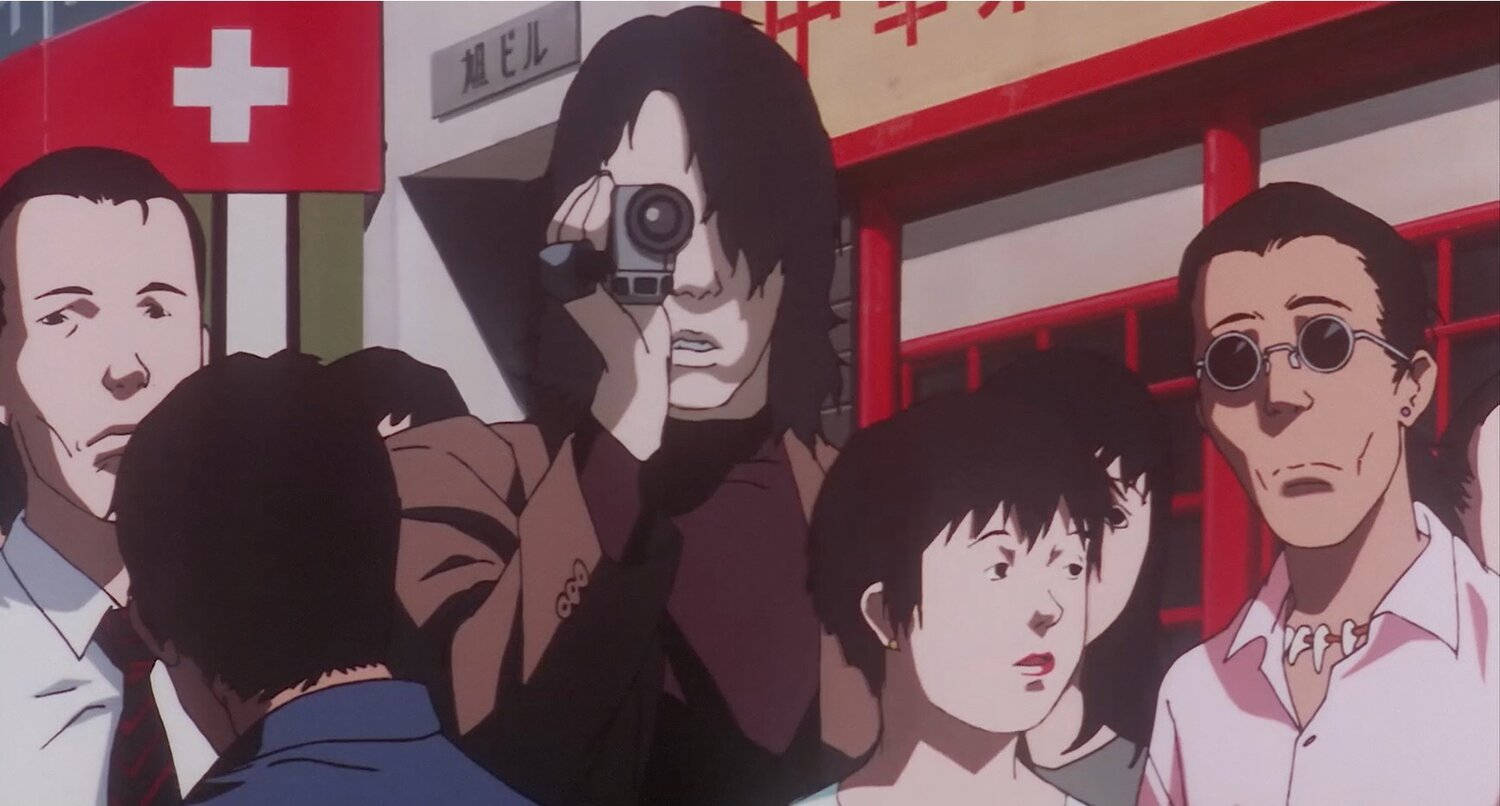 細川紘一經典之作——《Perfect Blue》 壁紙 — 一群動漫角色聚集在繁華的城市街道場景中，有紅色的店面和可見的瑞士國旗。