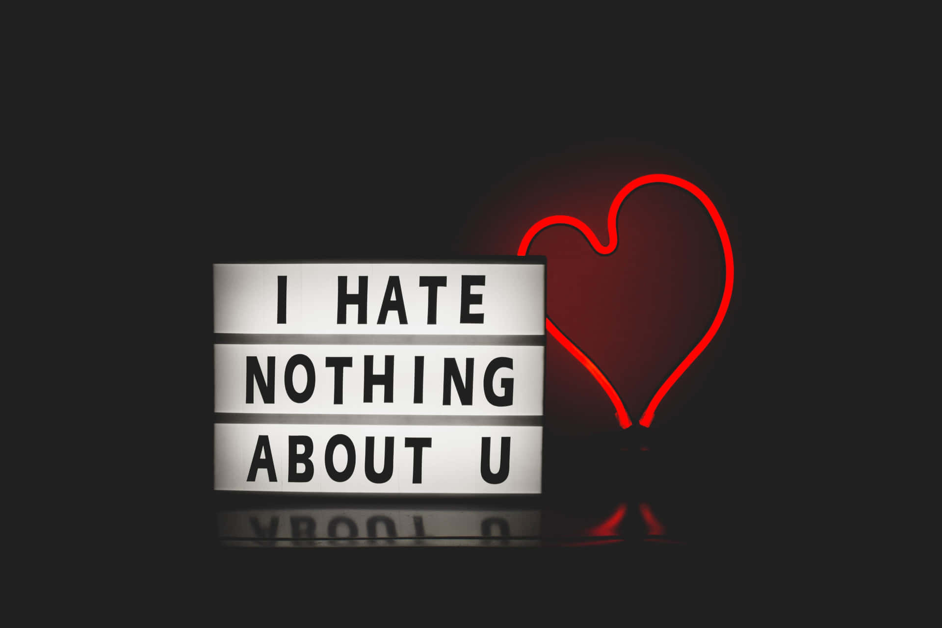 一個燈箱，上面有文字「I HATE NOTHING ABOUT U」，旁邊有一個紅色霓虹心形。