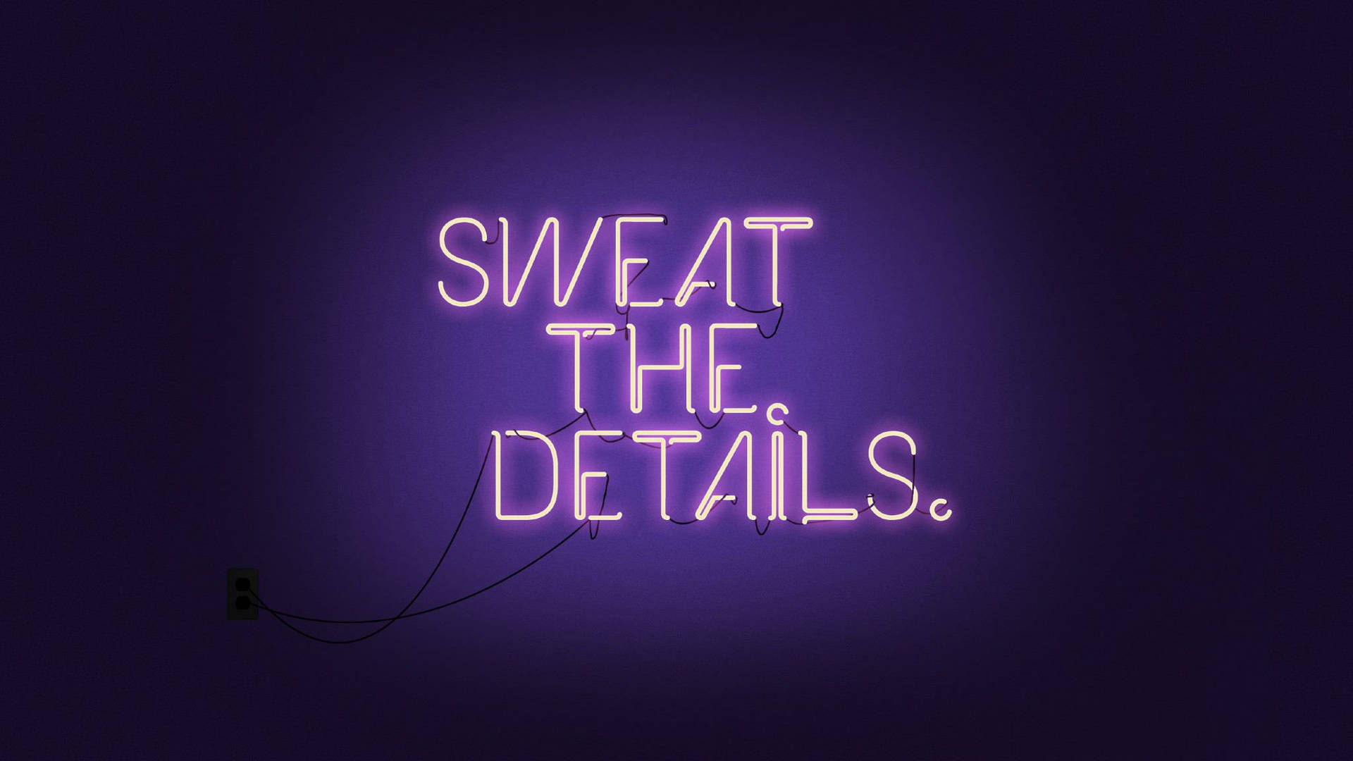 深色牆壁上寫著「SWEAT THE DETAILS」的紫色霓虹燈牌。