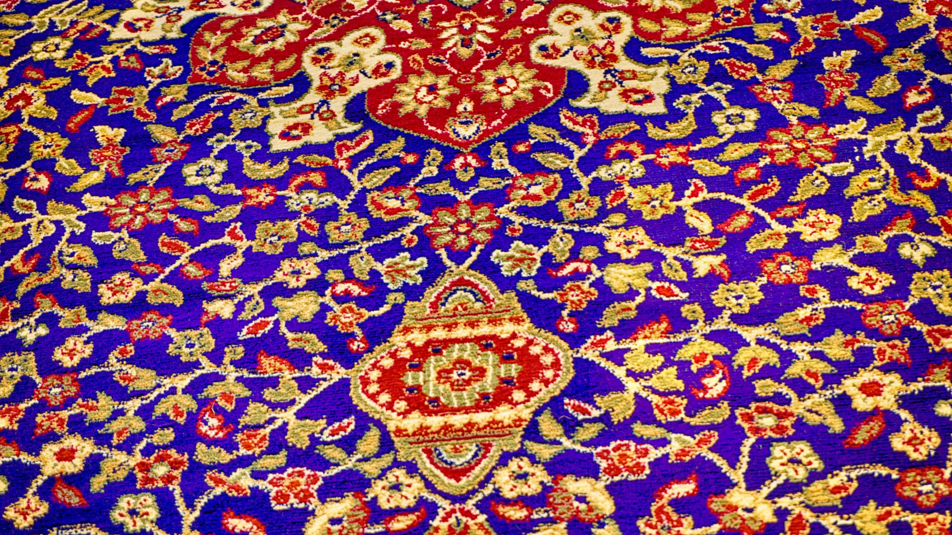 Carpet 桌布 壁紙 — 細節豐富嘅波斯地毯近鏡，深藍色底，紅色花卉圖案同金色點綴。