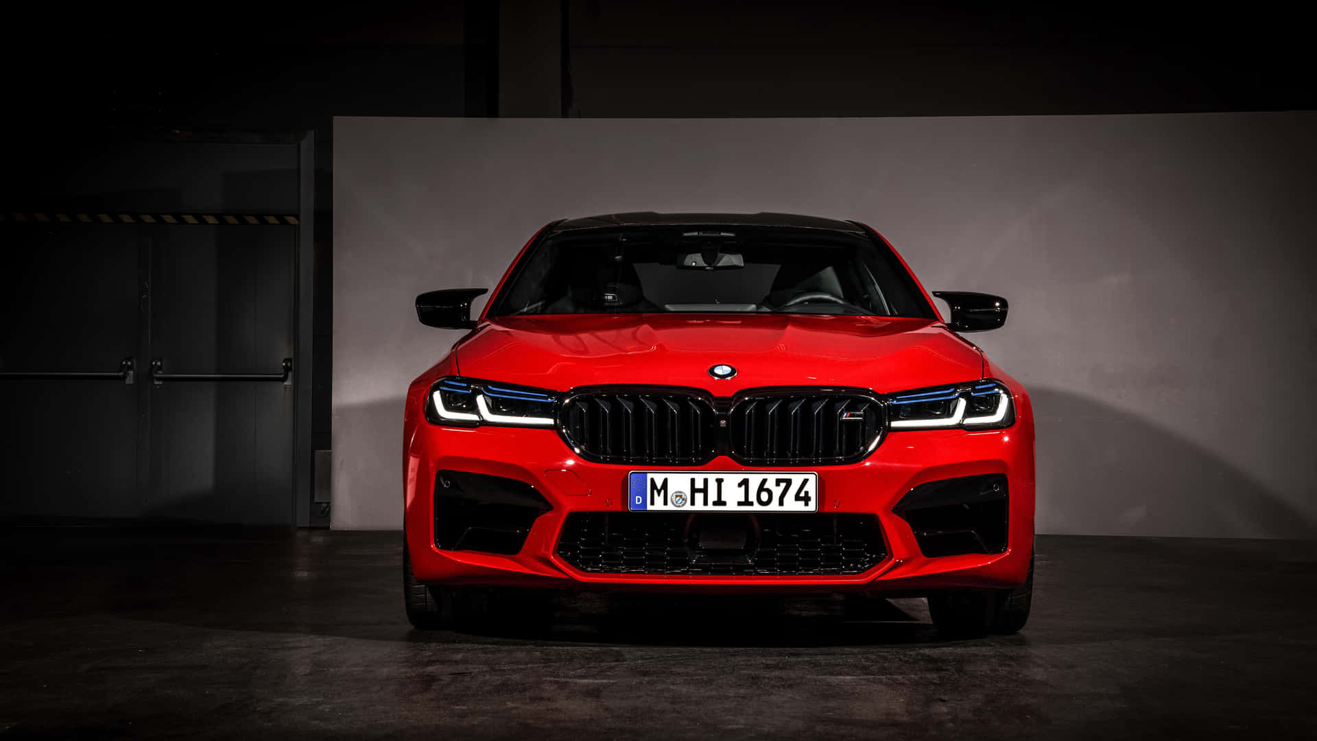 紅色BMW M5跑車在昏暗的車庫中帶有聚光燈效果。