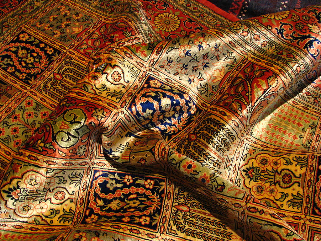 Carpet 桌布 壁紙 — 細節豐富的波斯地毯，帶有複雜的花卉和幾何圖案，採用溫暖的金色、紅色和藍色調，以柔軟的褶皺垂墜。