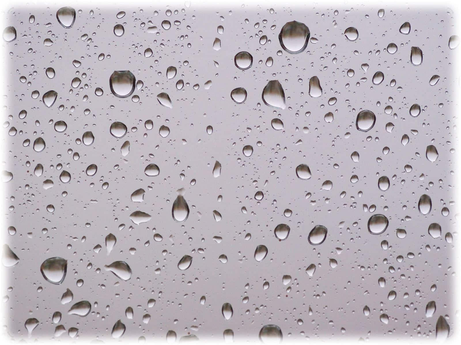 玻璃上的雨滴反射灰色天空