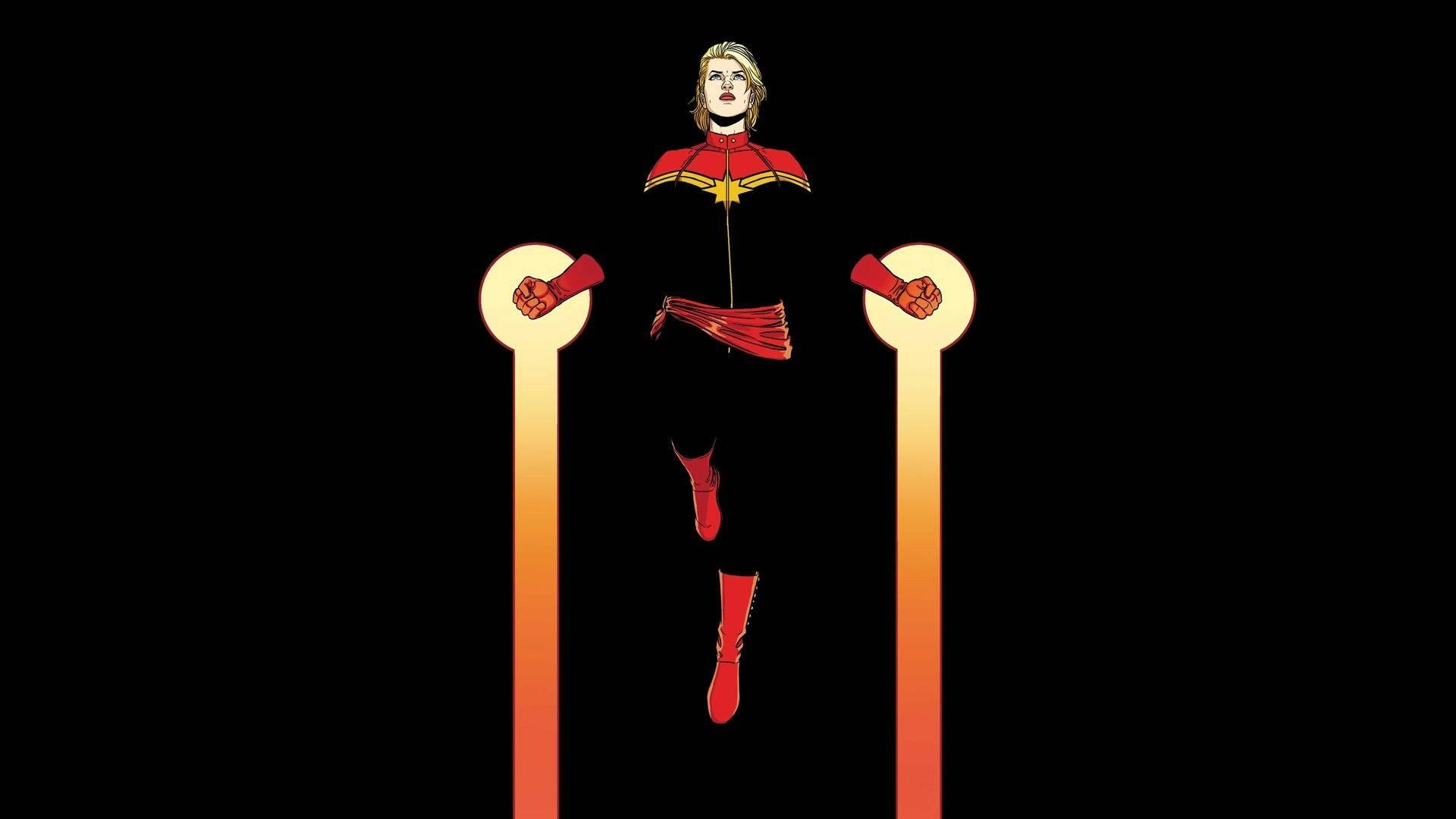 穿著紅黑色戰衣的Captain Marvel站在發光柱子之間。