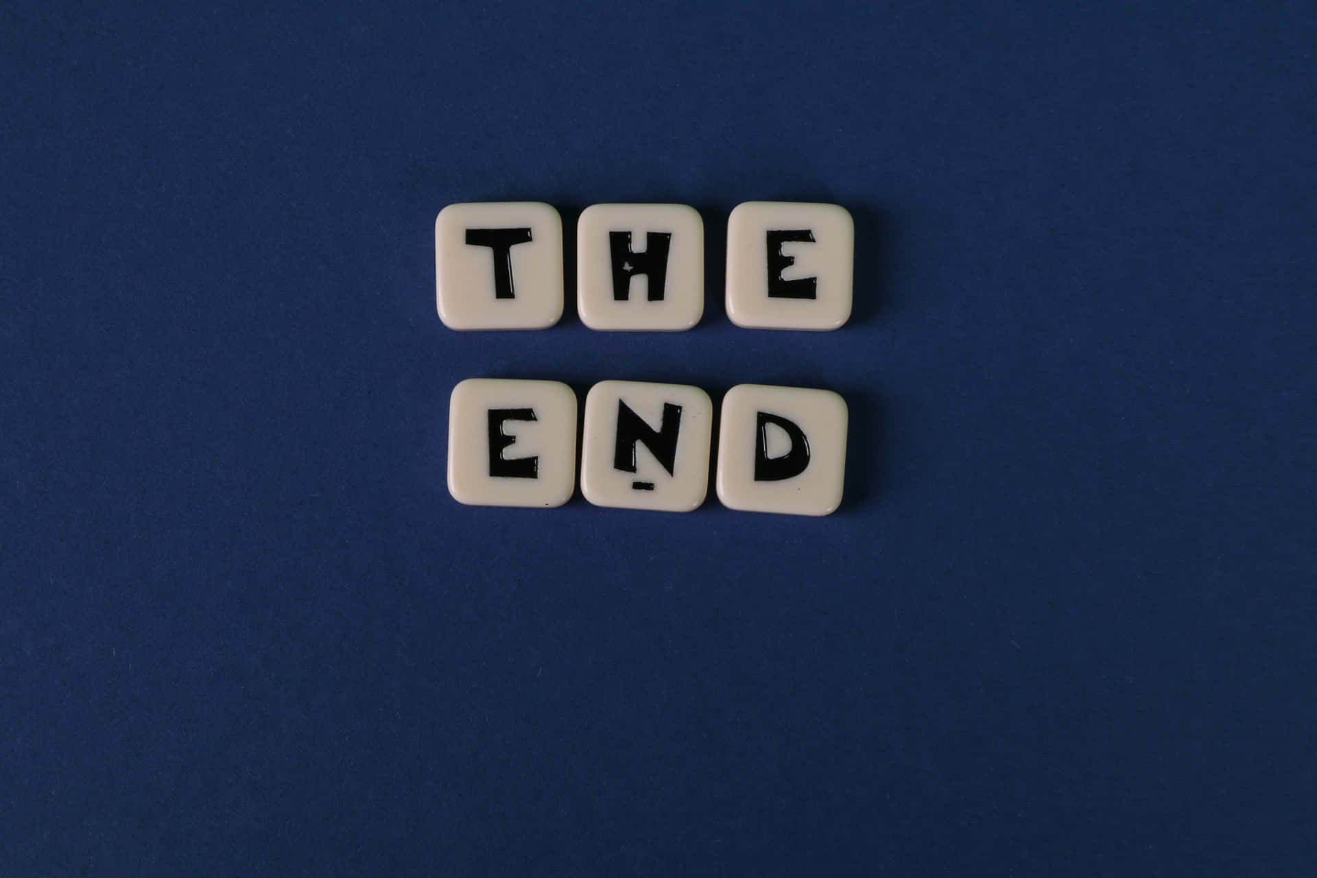 白色瓷磚上帶有黑色字母，在藍色背景上拼出「THE END」。