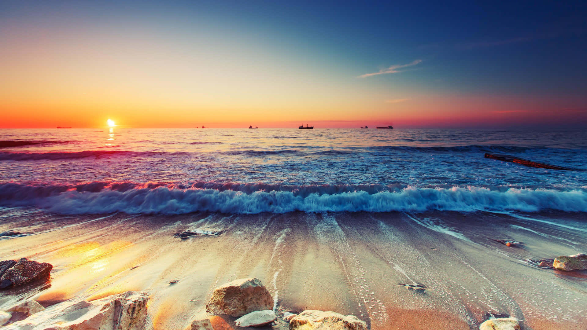 夕陽下的海洋，海浪拍打沙灘和岩石