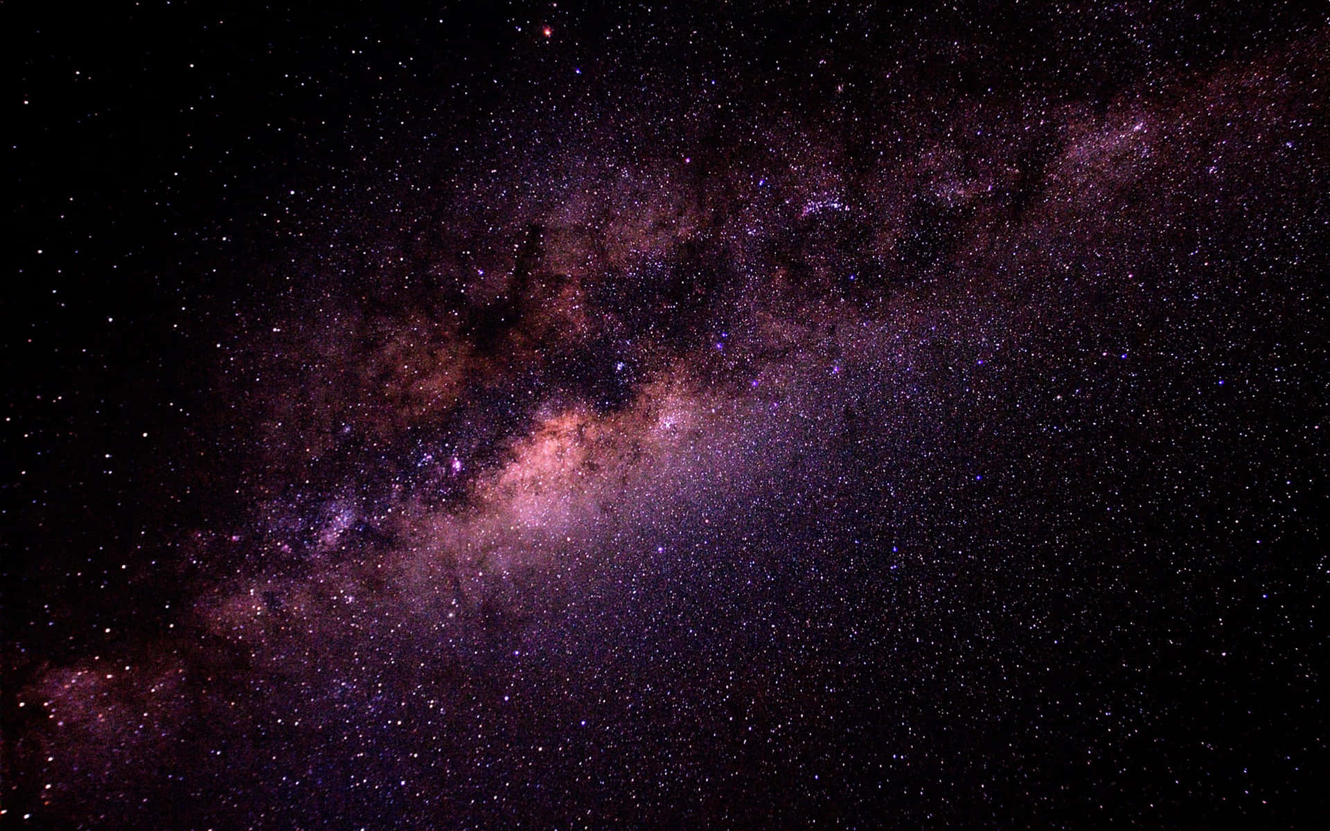 銀河系在夜空中閃耀著鮮豔的紫色和粉紅色星雲。