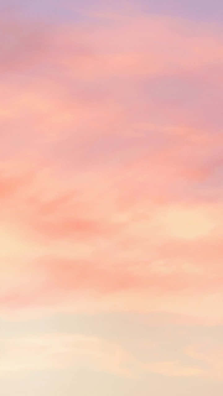 粉紅同蜜桃色雲朵喺寧靜嘅暮色天空中飄浮。