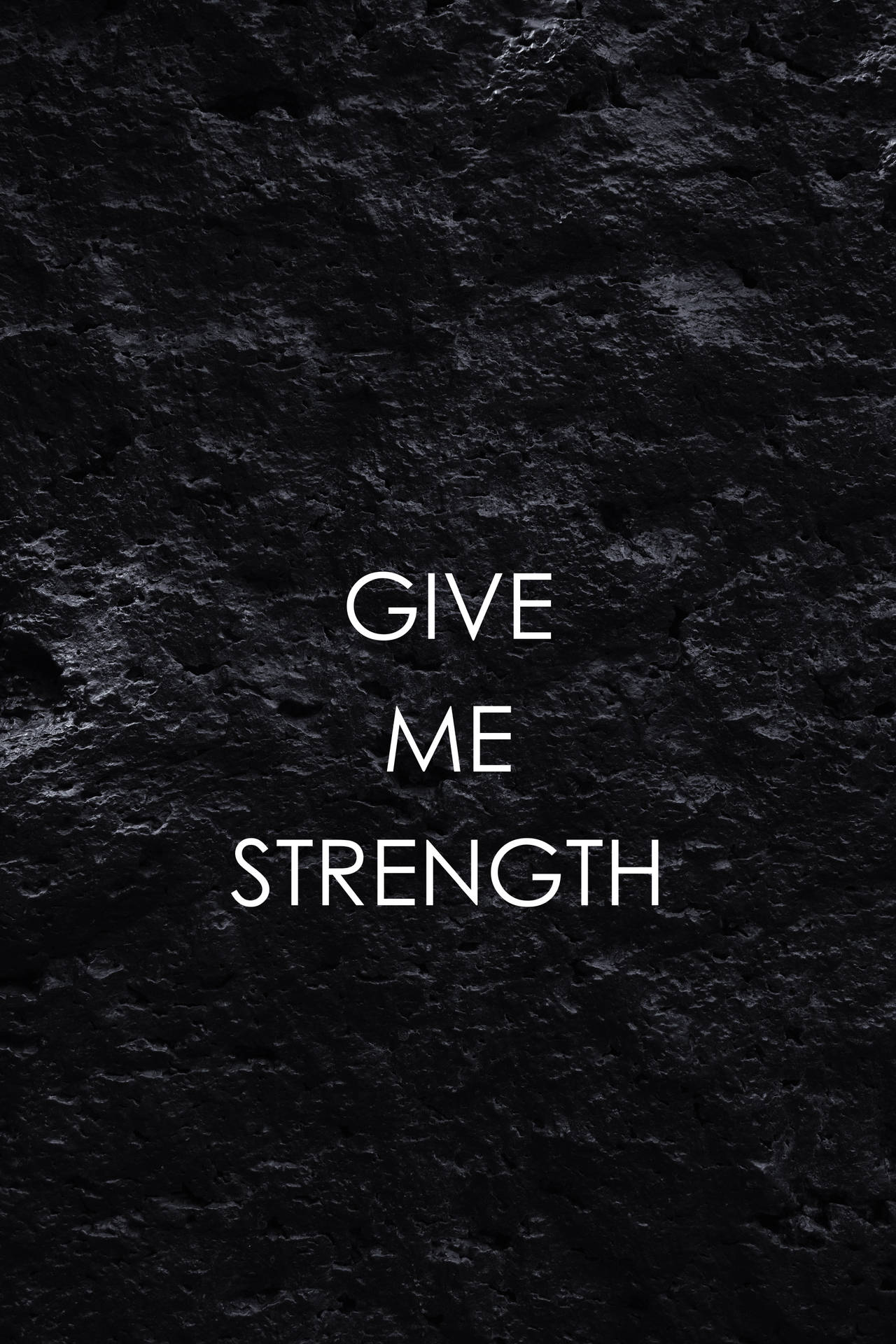 在深色石頭表面上寫著 give me strength 的文字。
