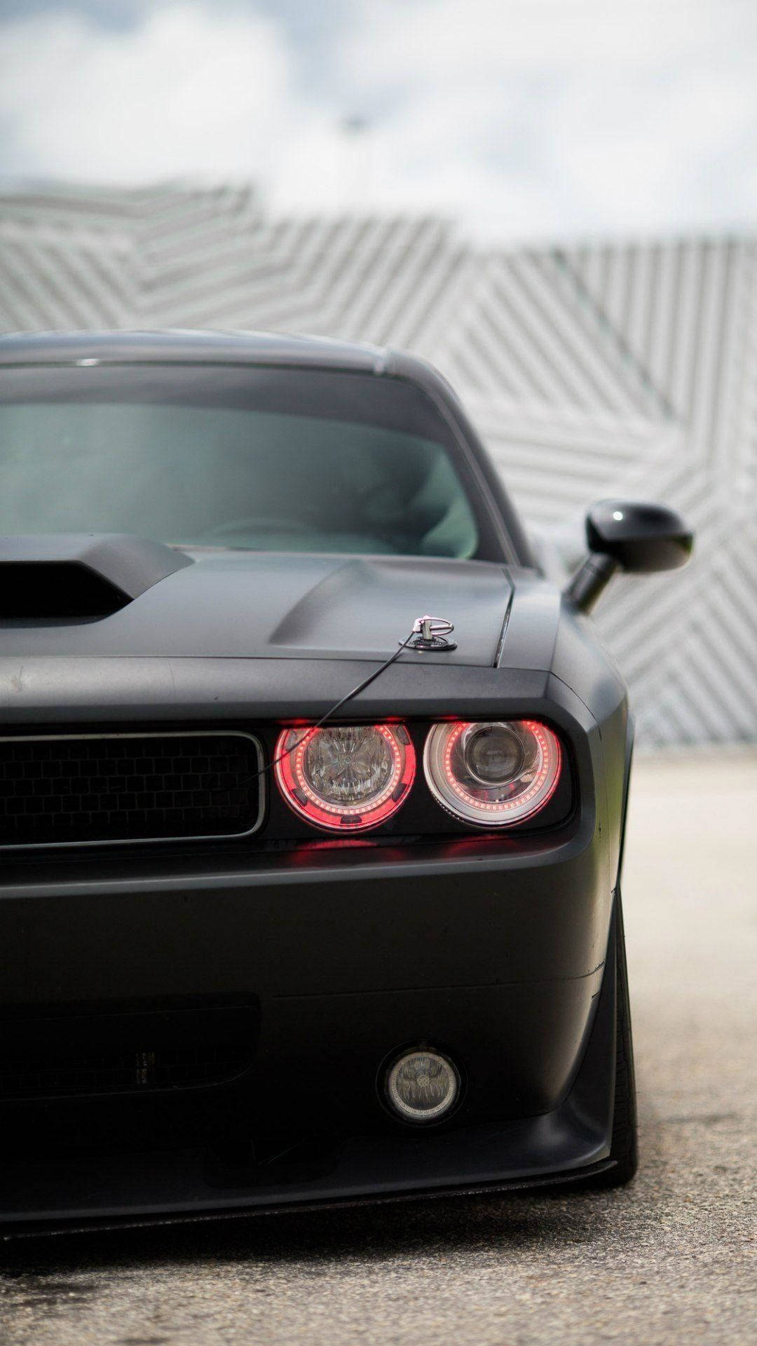 黑色肌肉車帶紅色頭燈停在條紋牆附近 — Dodge challenger GIF 壁紙
