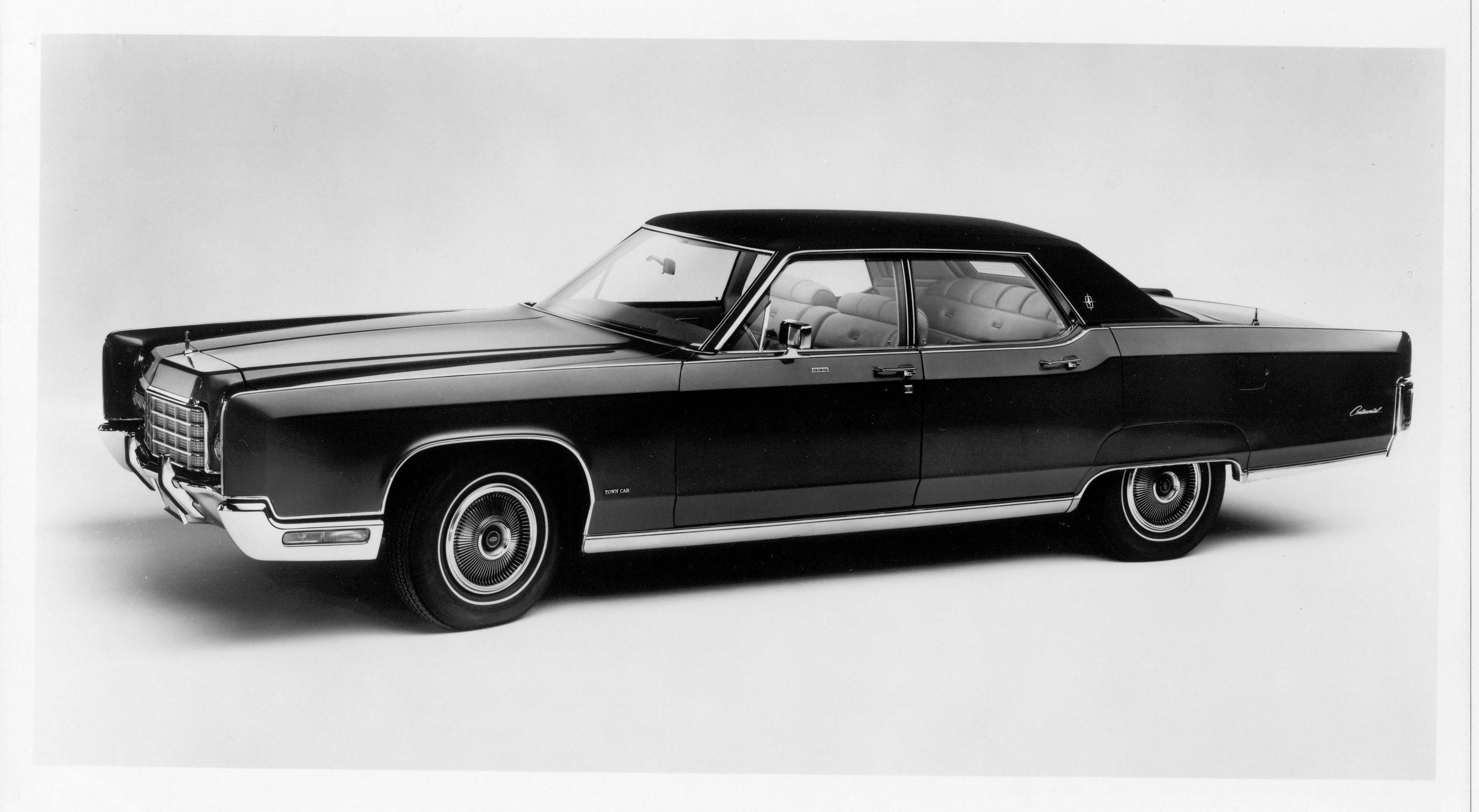 經典 1972 林肯 Continental 壁紙 — 一輛時尚的黑色經典汽車，帶有鍍鉻裝飾和白色側壁輪胎，在攝影棚中擺拍。