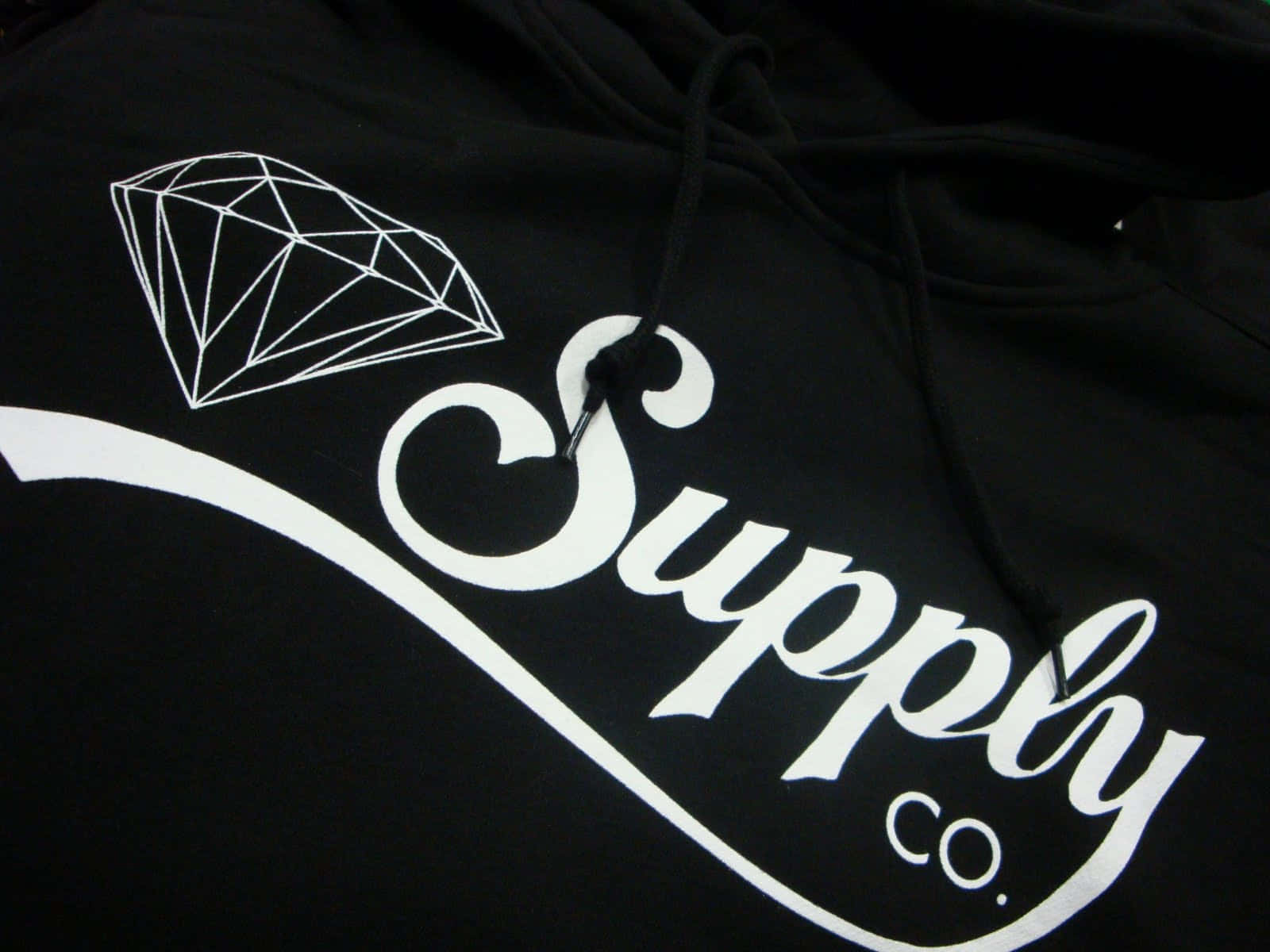黑色連帽衛衣，帶有白色鑽石標誌和Supply Co.文字。