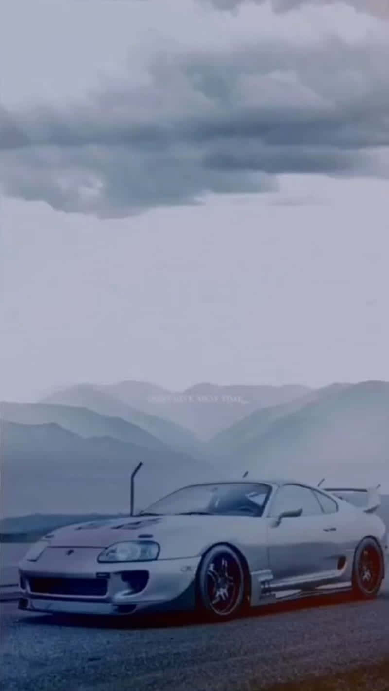 銀色豐田Supra停泊在多雲天空下的山路上。