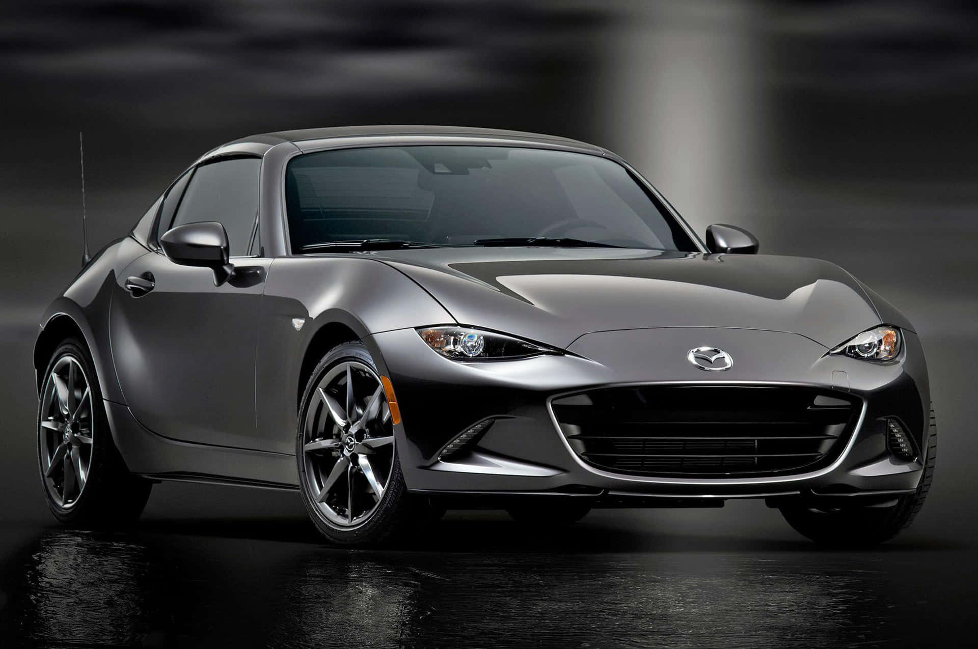 銀色Mazda MX-5 Miata跑車在潮濕路面上，工作室燈光下。