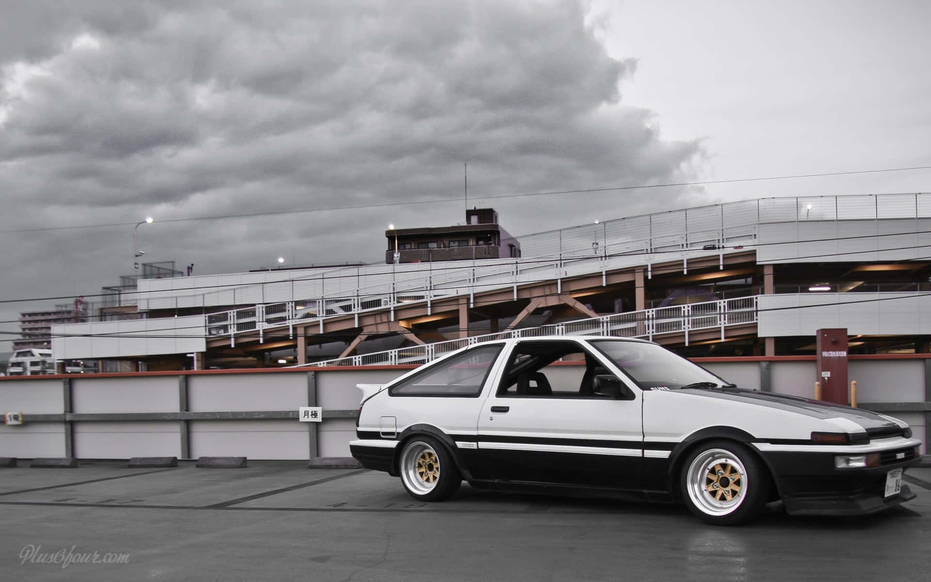 白色和黑色的AE86跑車停放在多層停車場。