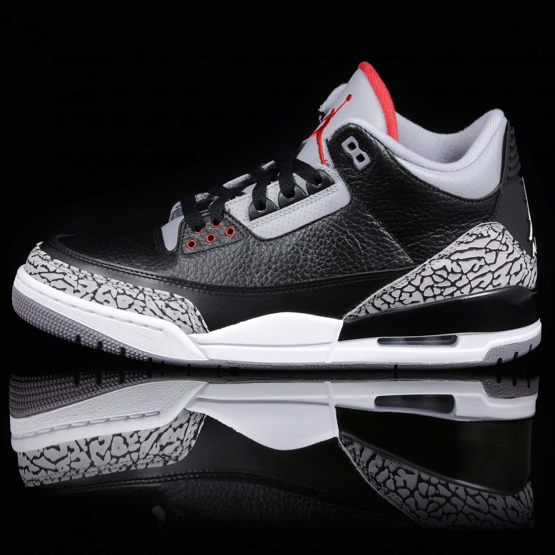 黑、白、紅色的 Air Jordan 3 運動鞋，象紋鞋底，反射表面。