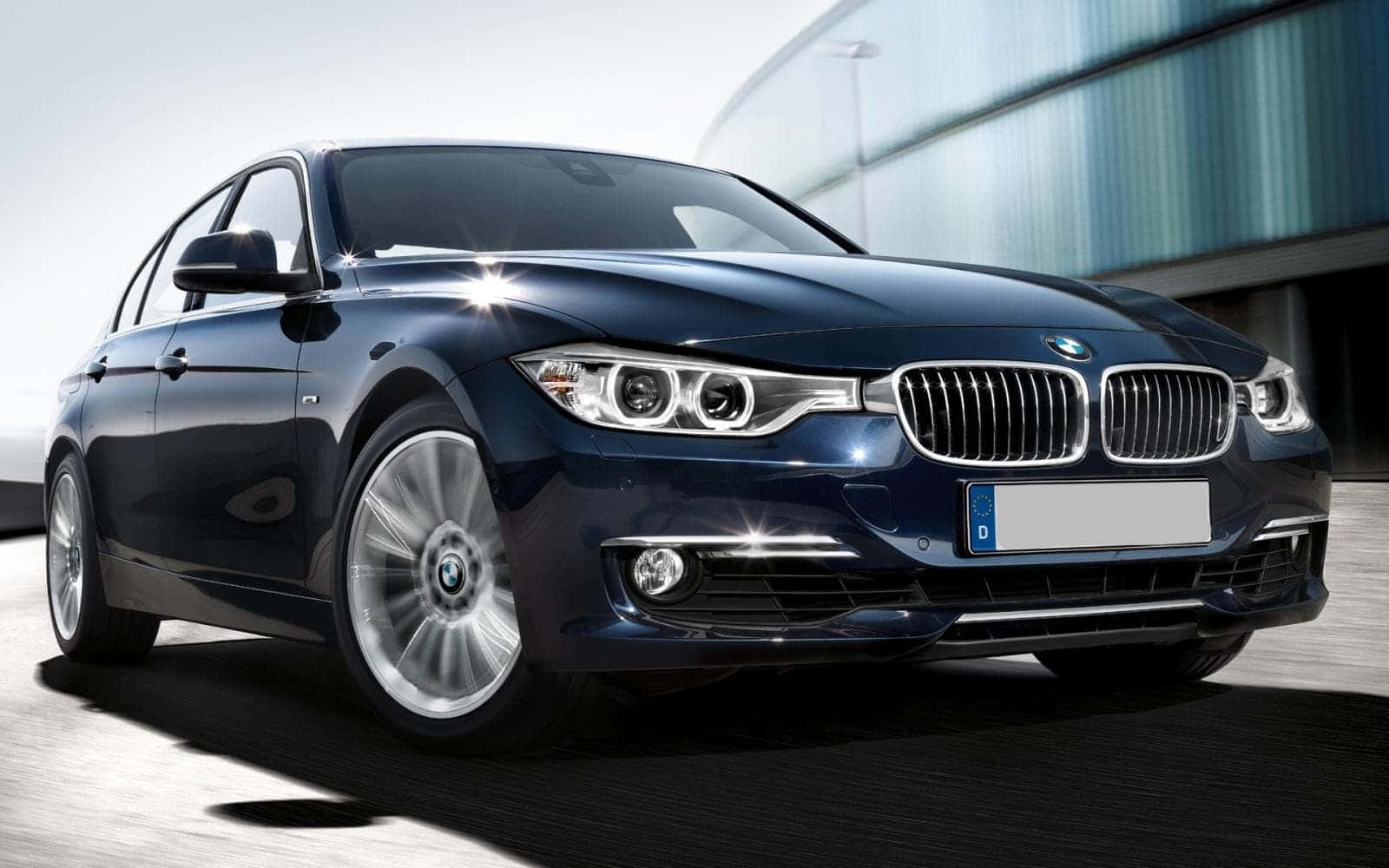深藍色BMW轎車停在現代建築前。
