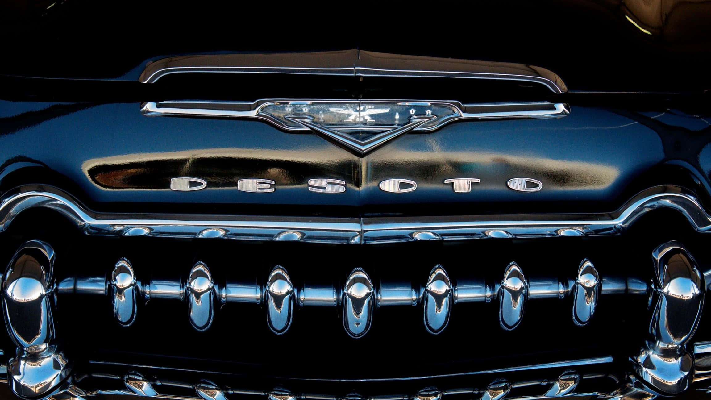 Car Grill 桌布 壁紙 — 經典DeSoto汽車閃亮鍍鉻格柵和引擎蓋標誌在戲劇性燈光下的特寫。