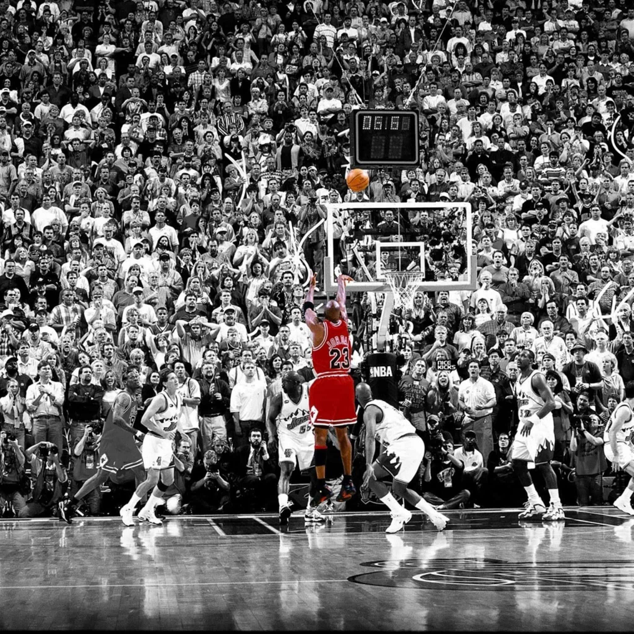 經典NBA球場的美學視覺 壁紙 — 一位身穿紅色球衣的籃球運動員在黑白競技場中灌籃，觀眾在旁觀看。