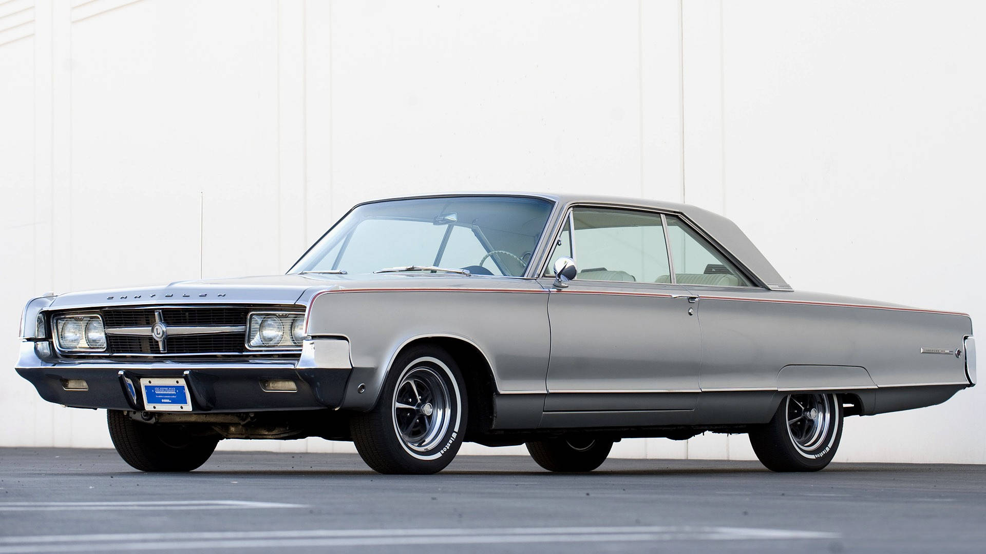 經典優雅 - 1965 Chrysler 300L 全貌 壁紙 — 一輛時尚的銀色經典汽車，帶有鍍鉻裝飾和白色輪胎，停放在純白色牆壁前。