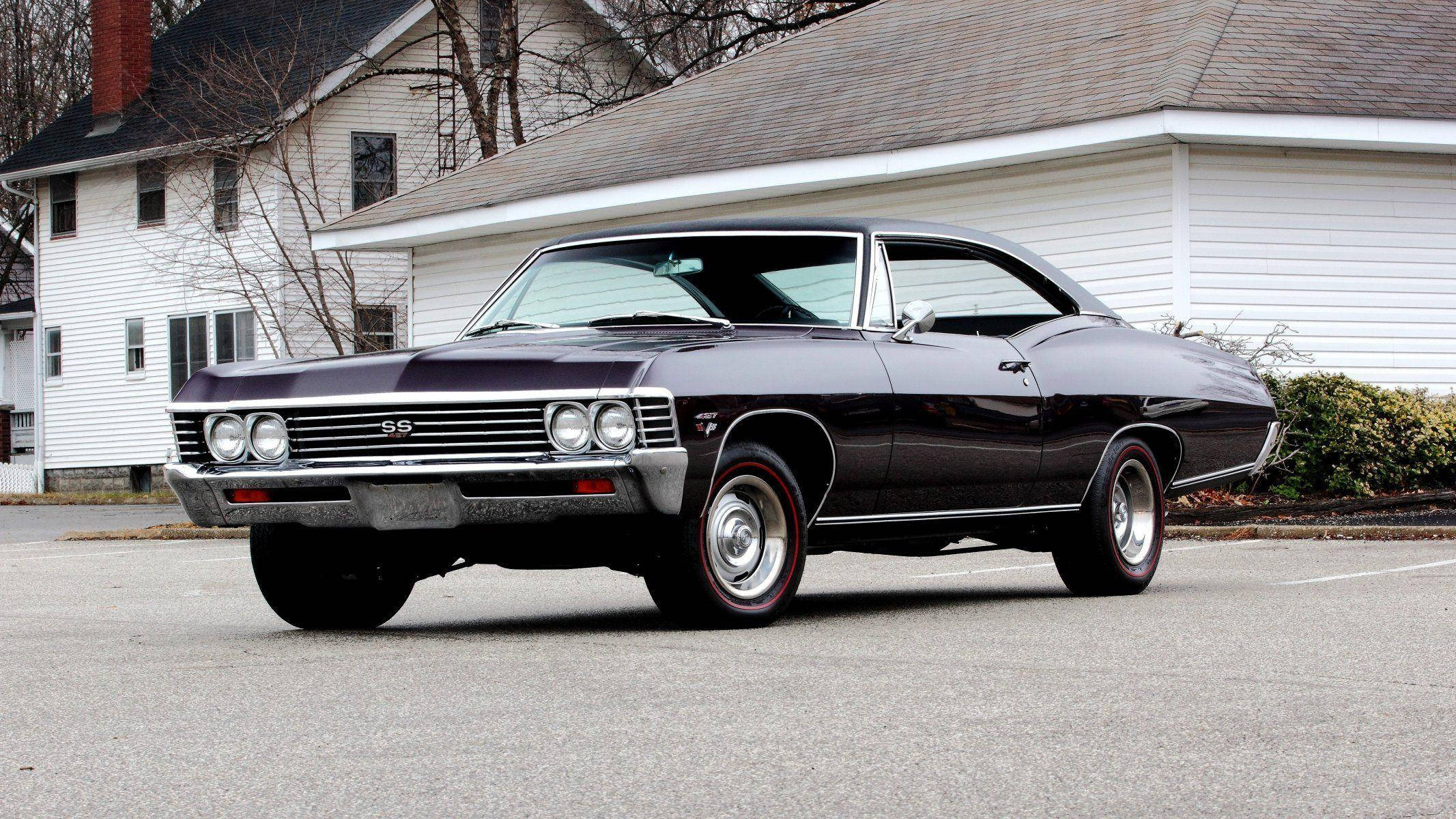 經典優雅1967雪佛蘭Impala SS 427 壁紙 — 一架亮黑色經典雪佛蘭SS肌肉車停泊在瀝青路上，前面是一間有光禿樹木的白屋。