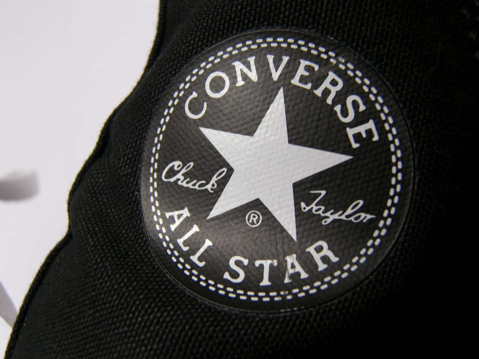 帆布運動鞋上的黑色Converse All Star標誌布章。