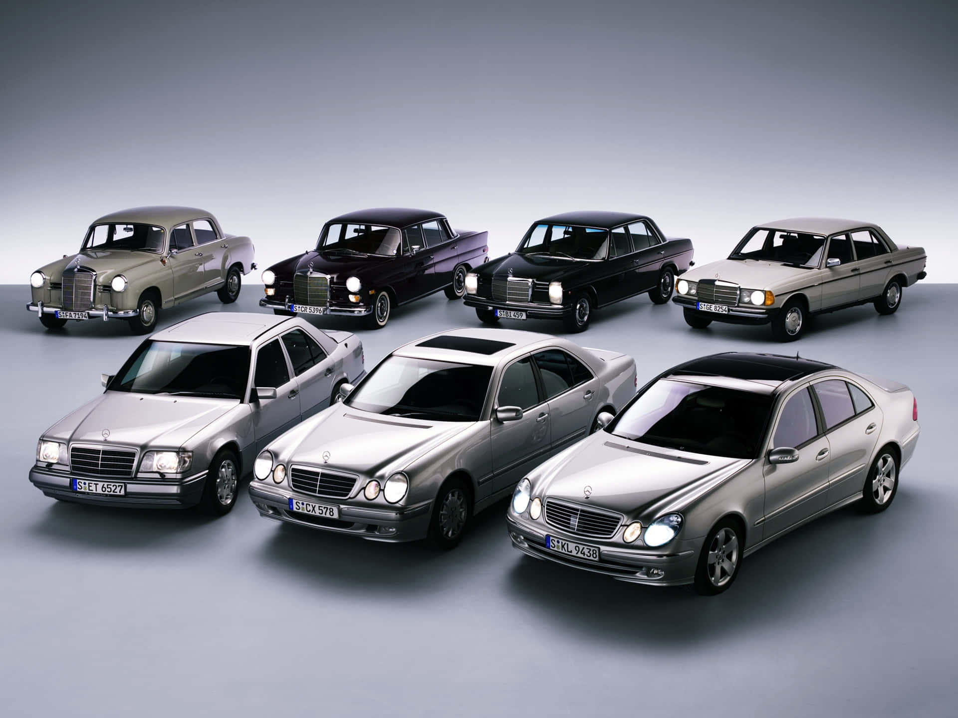 七輛 Mercedes-Benz 房車在漸變灰色背景的攝影棚網格中展示。