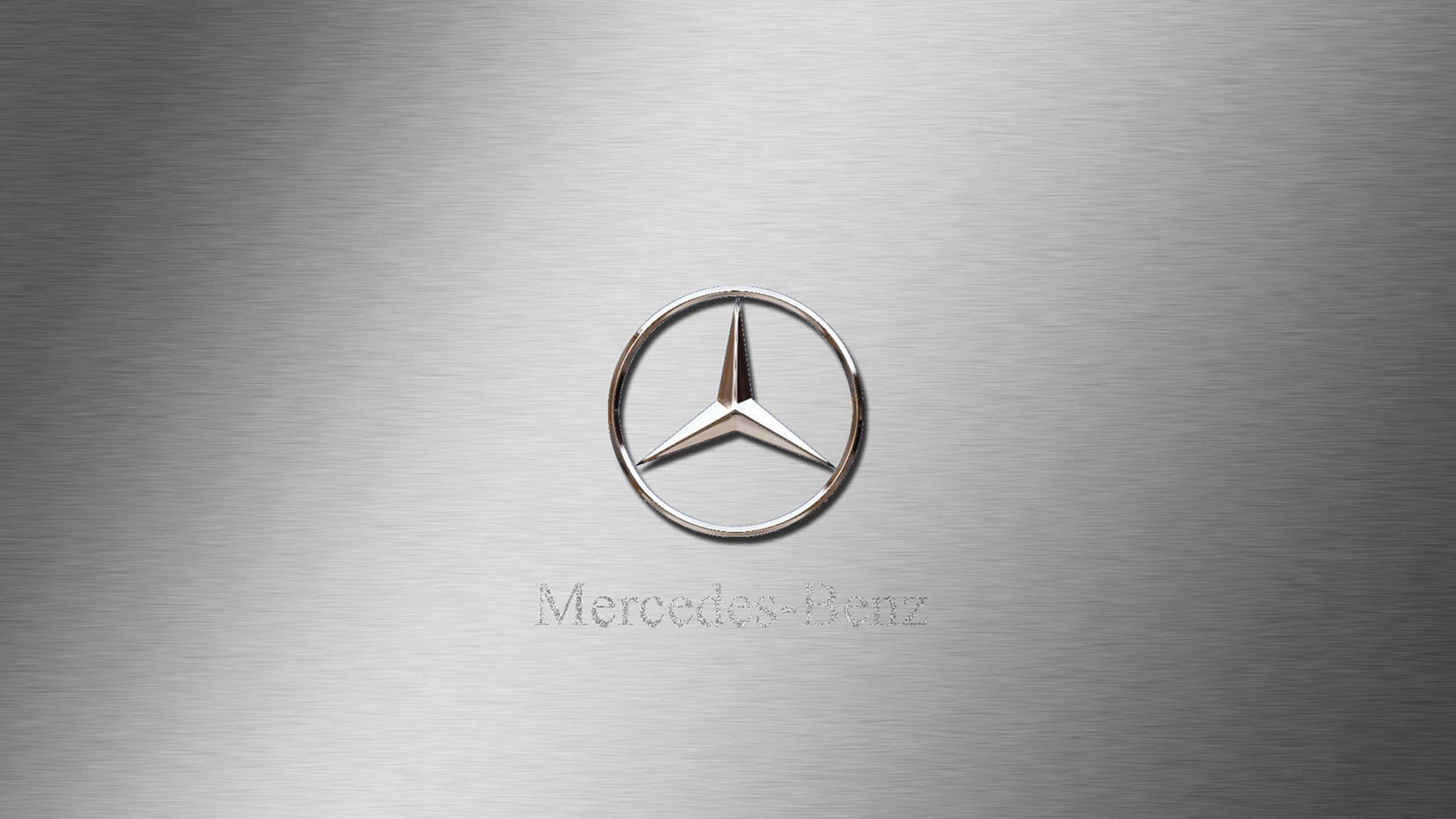 經典梅賽德斯-奔馳標誌：黑銀配色 壁紙 — 一個拋光銀色 Mercedes-Benz 標誌，居中於拉絲金屬背景上，帶有微妙的燈光反射。