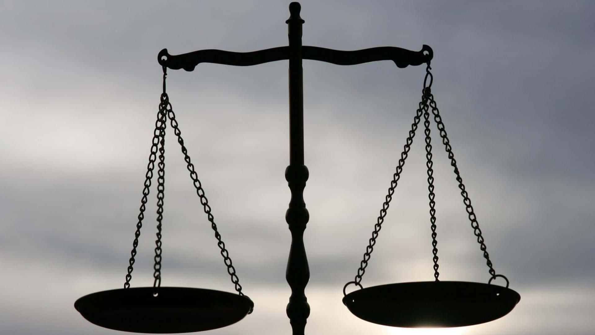 libra 桌布 壁紙 — 經典正義天秤的剪影，背景為多雲的灰色天空，秤盤平衡。