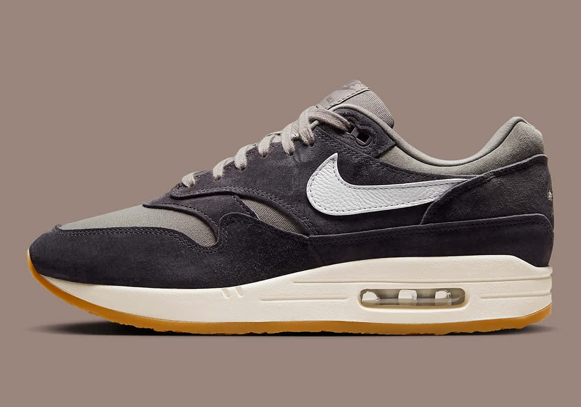 深灰色 Nike Air Max 1 運動鞋，帶有白色勾勾和橡膠鞋底。