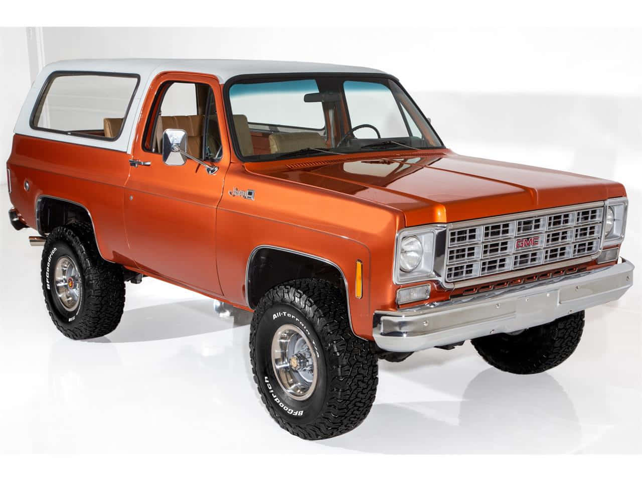 Gmc Jimmy 桌布 壁紙 — 經典的橙色和白色GMC Jimmy SUV，帶有鍍鉻裝飾和堅固輪胎，矗立在純白色的攝影棚地板上。