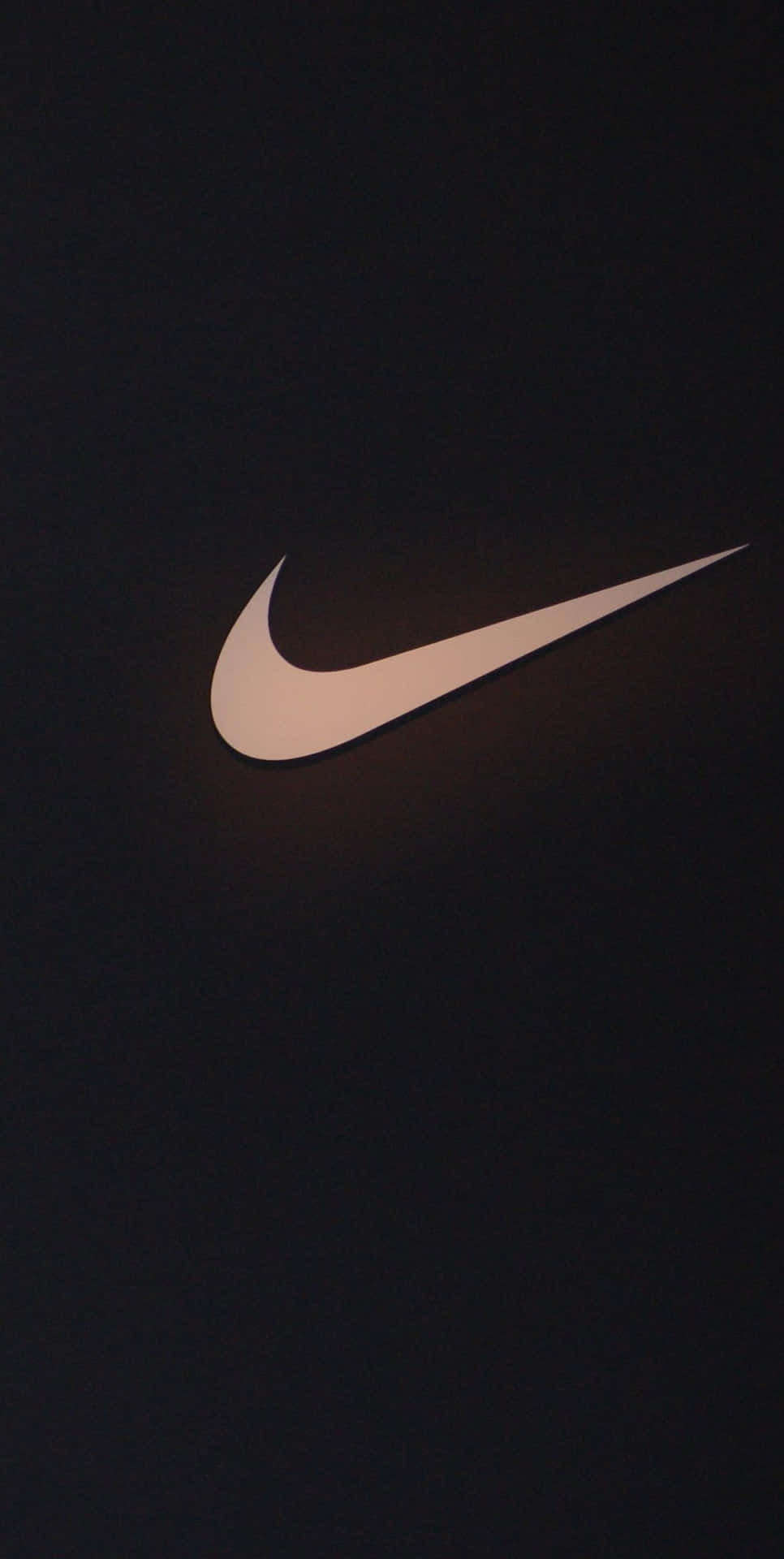 一個在深色背景上照亮的白色Nike Swoosh標誌。