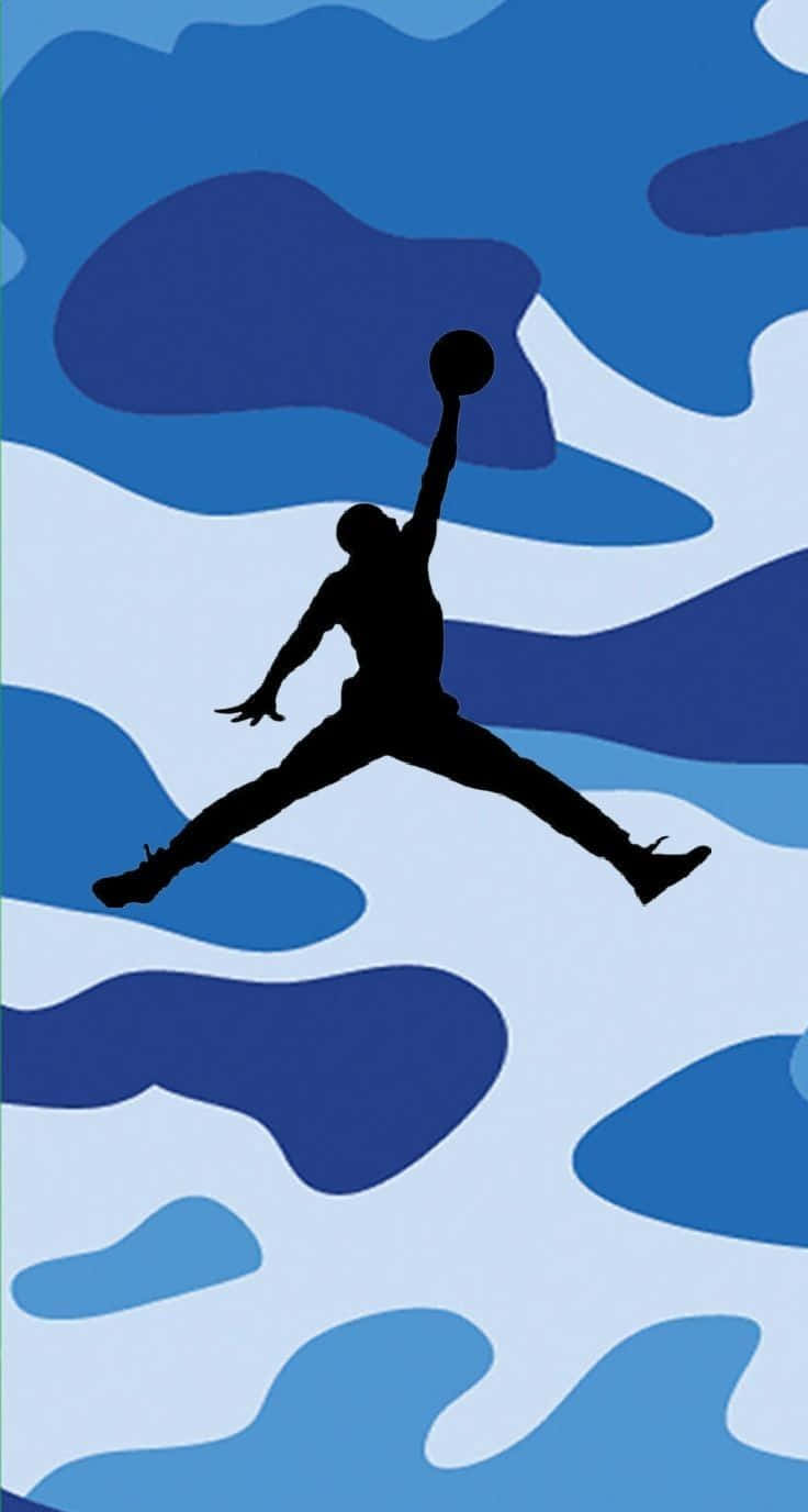 經典藍色Jordan運動鞋的熱情展現 壁紙 — 一個黑色剪影的籃球運動員在半空中入樽，背景是藍白迷彩圖案。