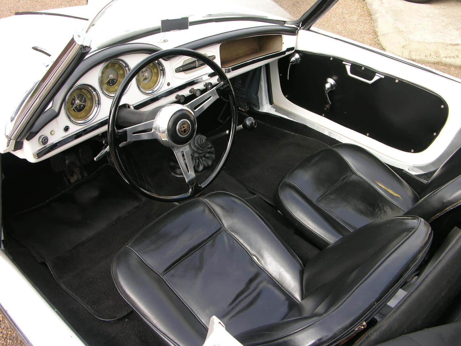 Alfa Romeo Spider 桌布 壁紙 — 經典跑車內飾，配備黑色皮革座椅和鍍鉻儀表板，帶有經典圓形儀錶。