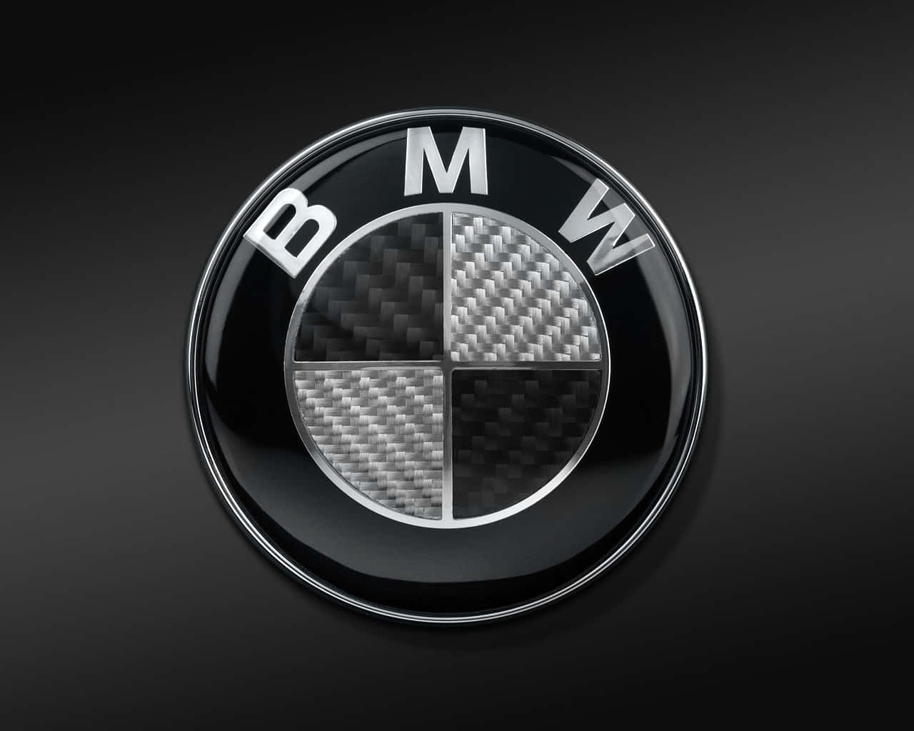 經典銀色與藍白BMW標誌 壁紙 — 一個帶有碳纖維四分之一圓的光澤BMW標誌，在深色漸變背景上閃耀。