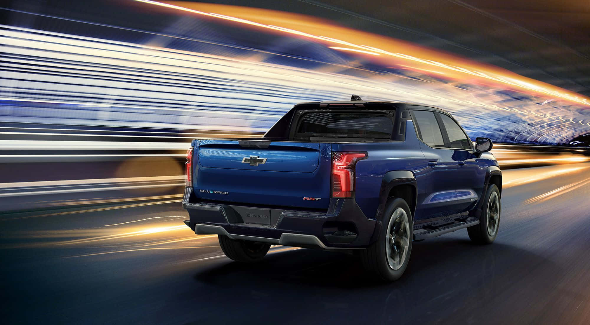 經典風情：駕駛這輛復古雪佛蘭Cruiser 壁紙 — 一輛藍色 Chevrolet Silverado F-150 RST 皮卡在夜間高速行駛於高速公路，燈光拖曳形成動態模糊效果。