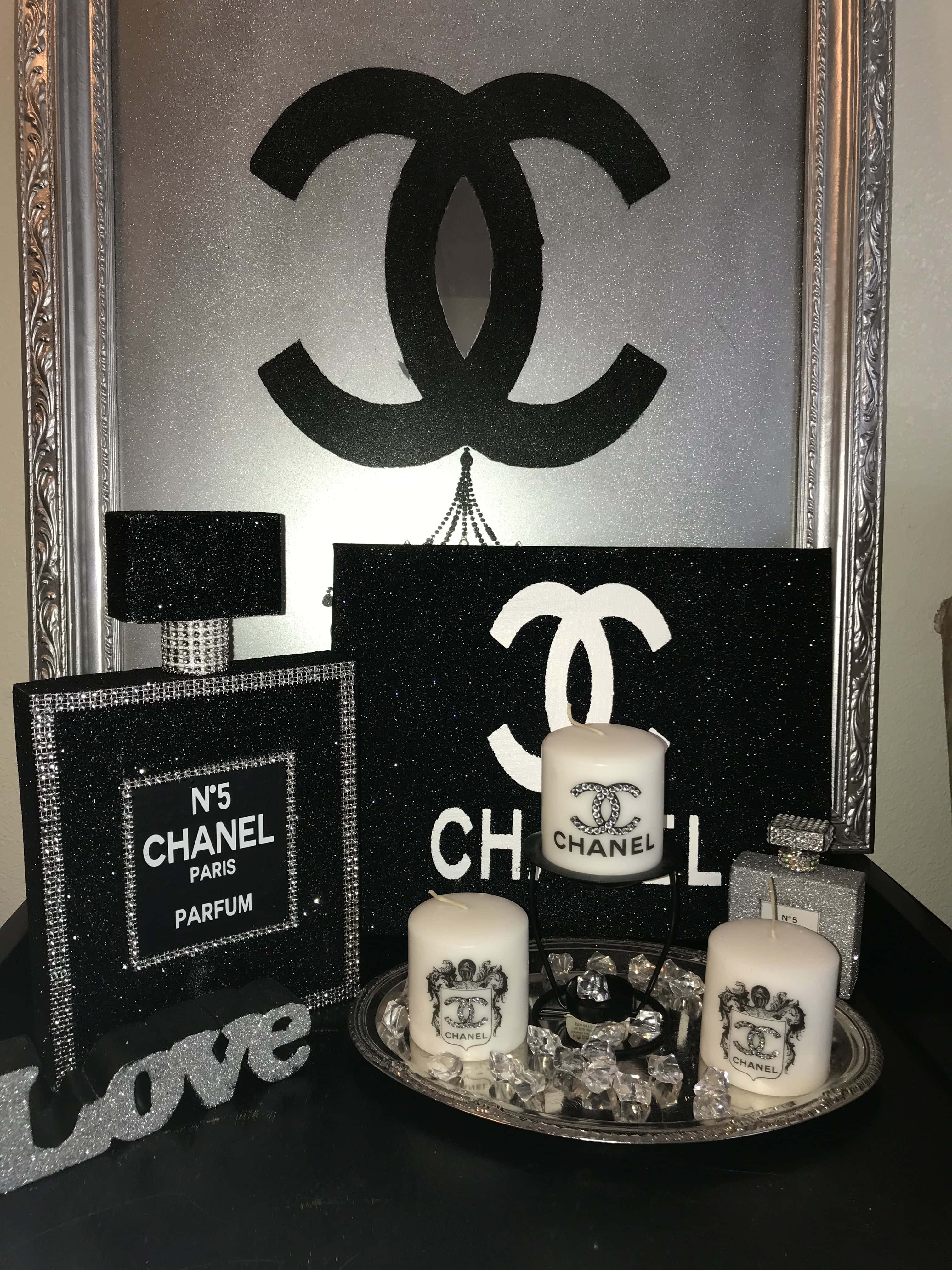 經典香奈兒標誌 壁紙 — 一個華麗的黑銀色 Chanel 主題裝飾展示，包含閃閃發光的香水瓶、蠟燭和標誌性標誌藝術。