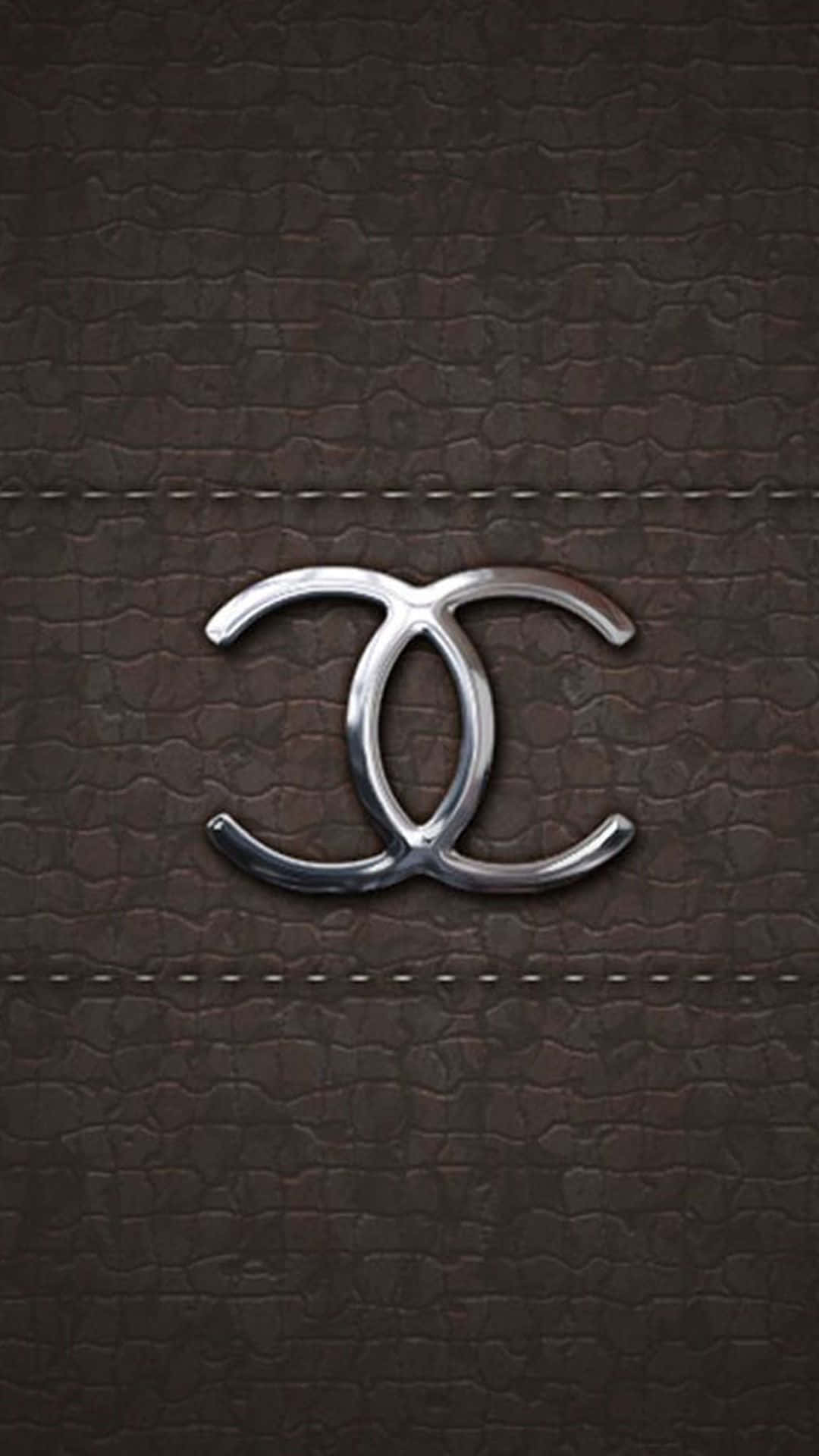 銀色 Chanel 標誌在棕色皮革上，帶有縫線