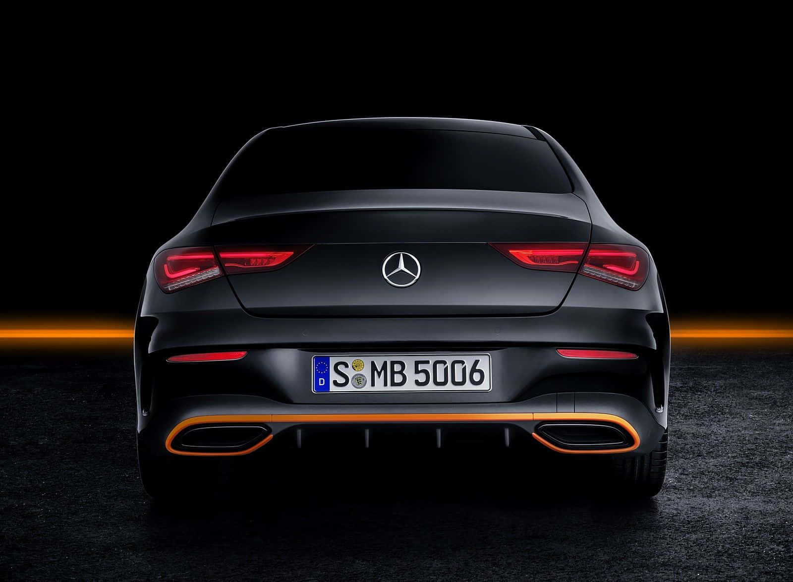 黑色 Mercedes-Benz CLA 後視圖，帶有發光尾燈和橙色排氣飾條。